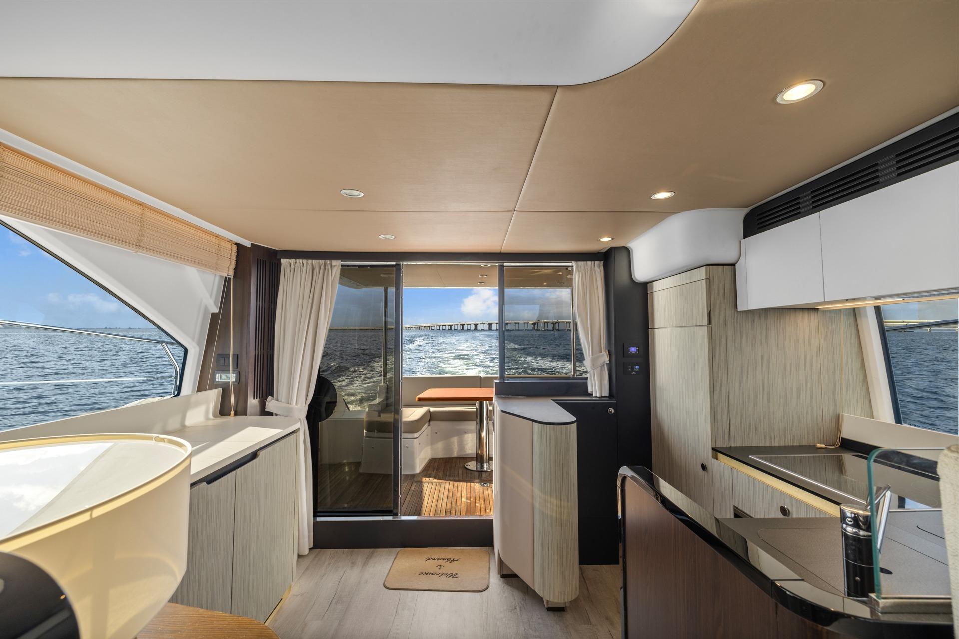 Luxurious interior of 2019 Azimut 55 yacht with ocean view through large windows.