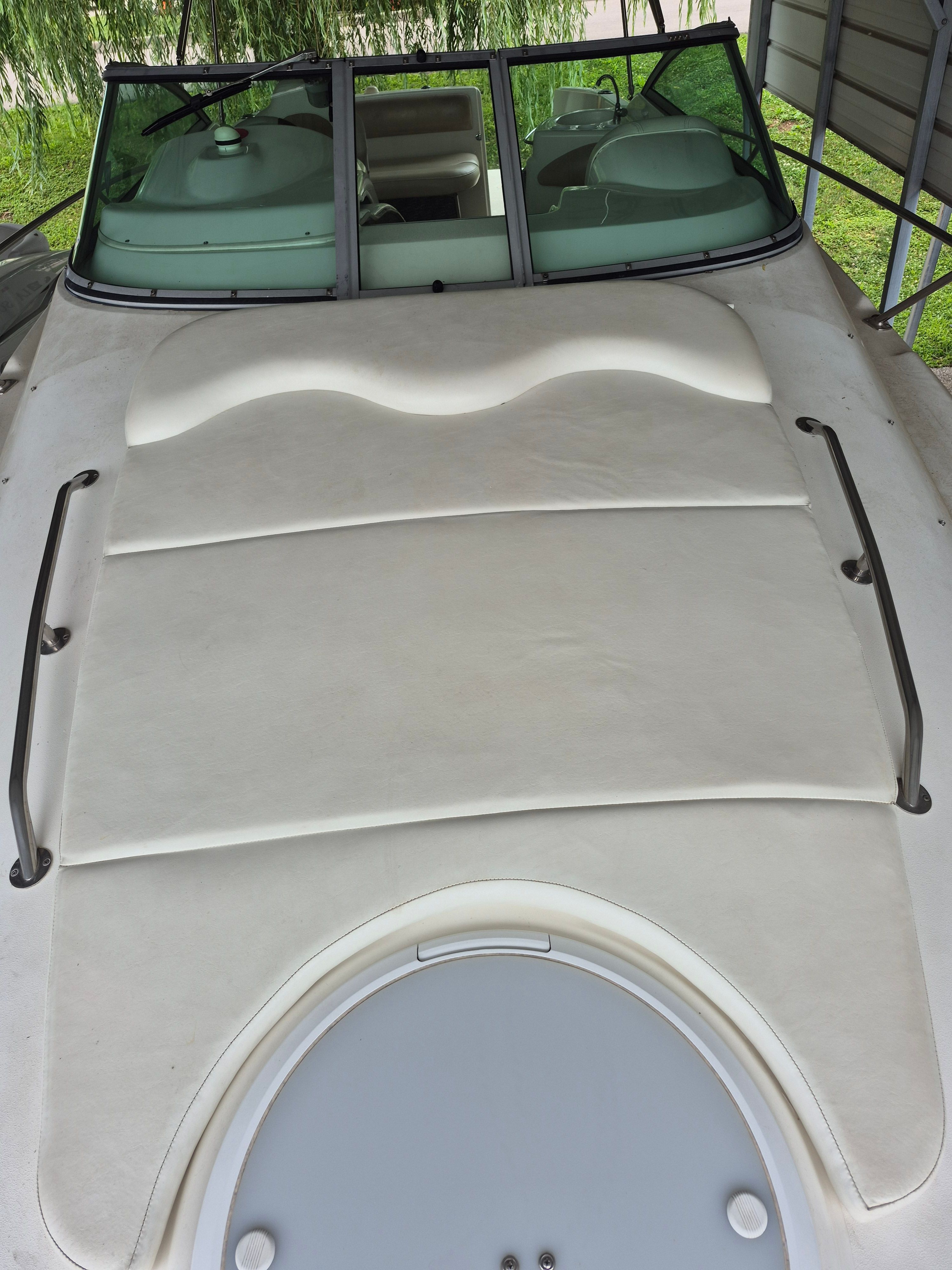The image shows the deck of a 2004 Larson Cabrio 274 with sun pad and windshield.