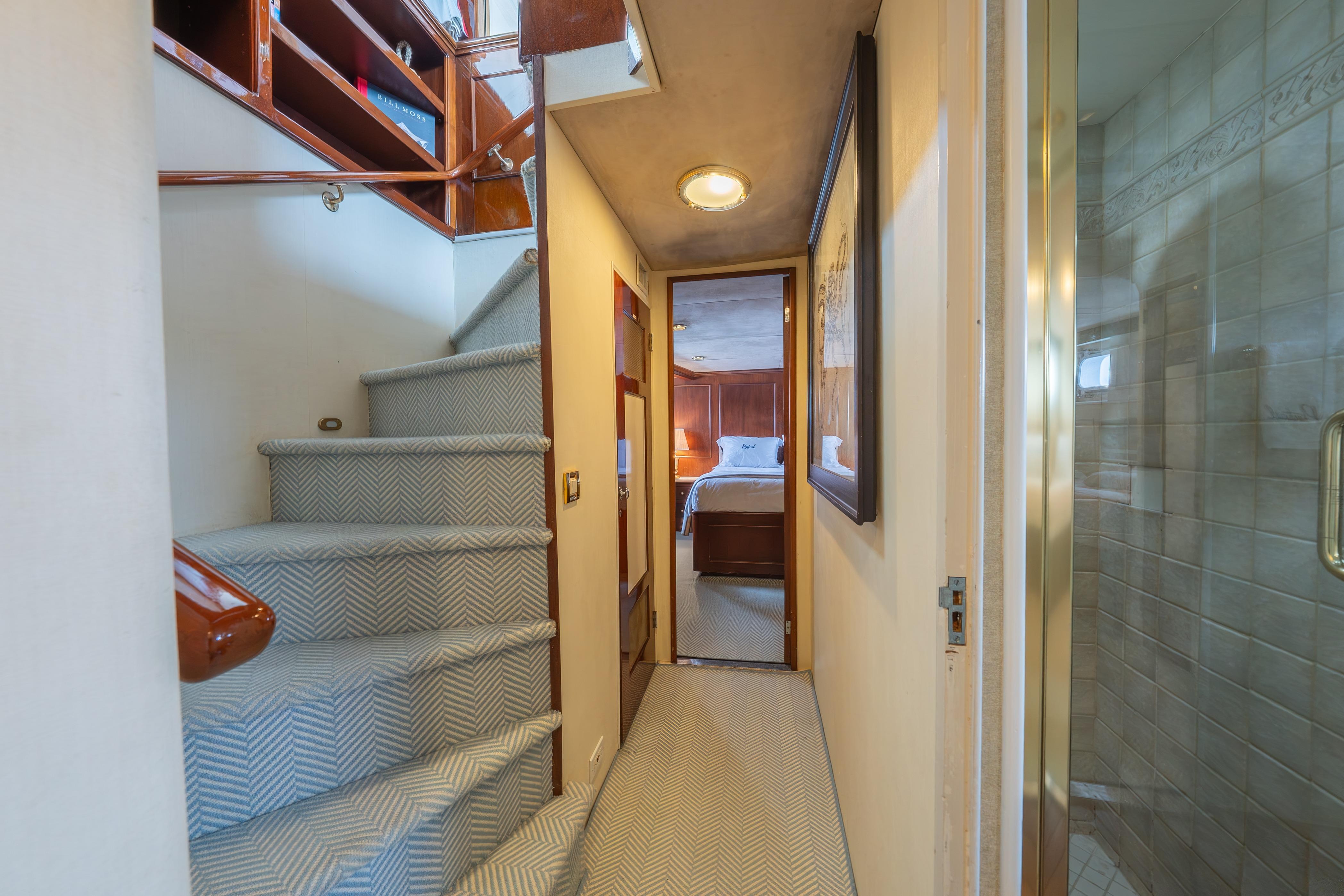 Interior of a 1963 Trumpy Classic yacht with stairs and cozy bedroom.