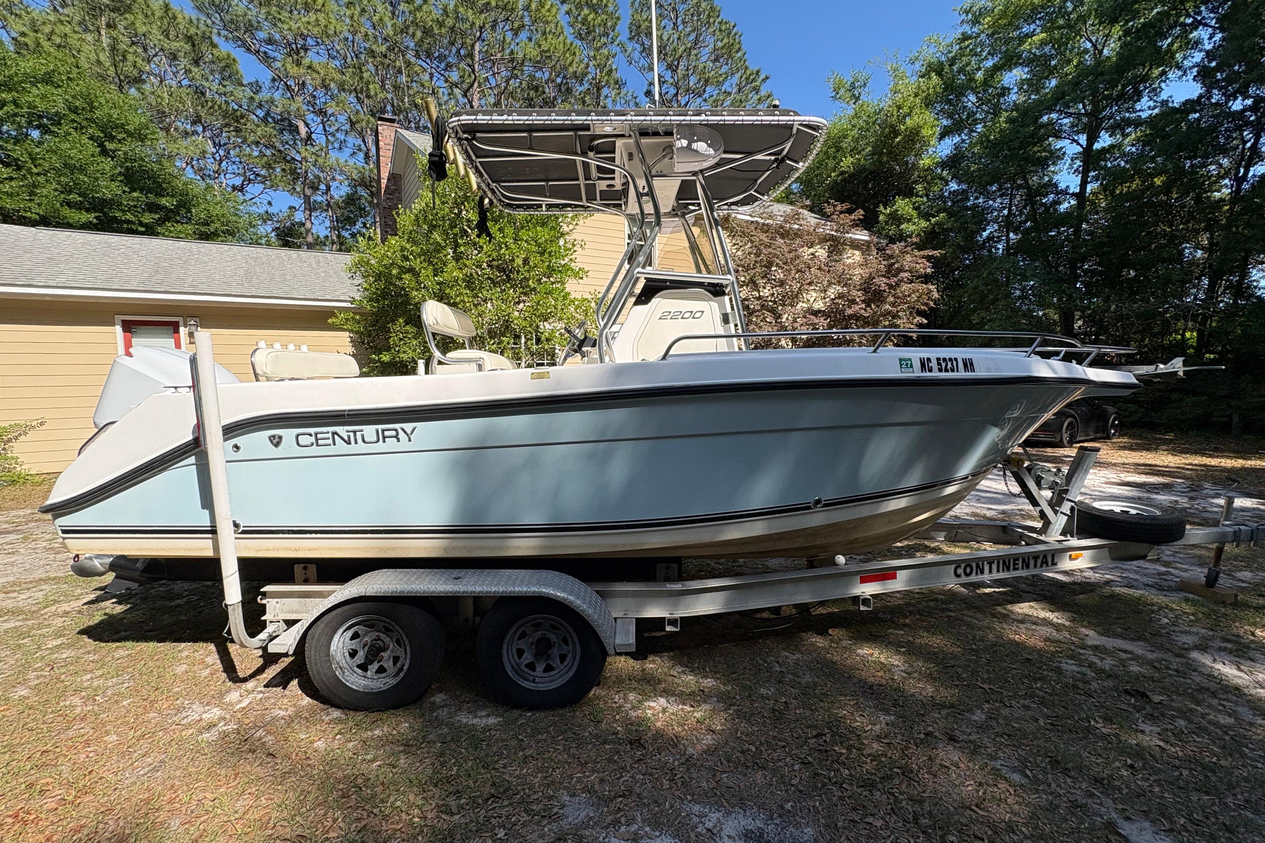 2005 Century 2200 Center Console boat on trailer, parked outdoors.