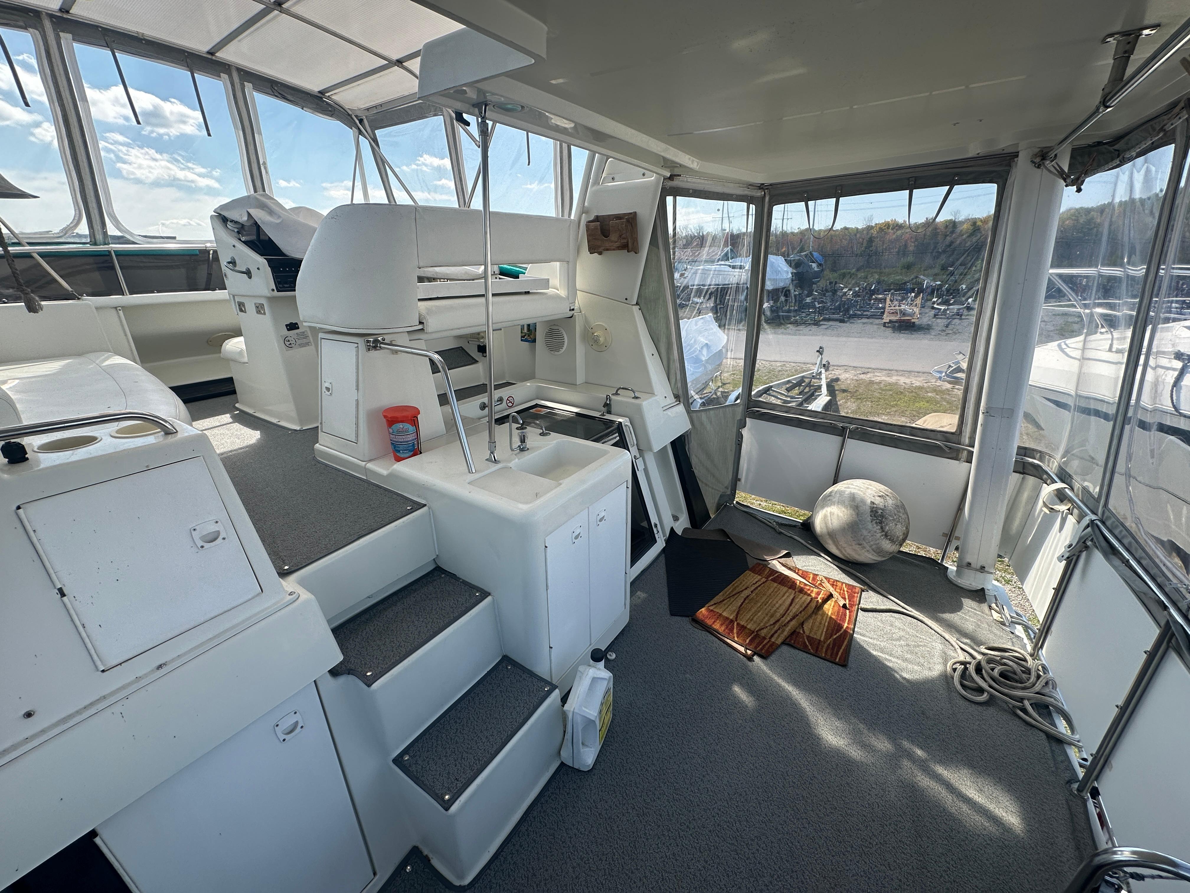 1994 Silverton 34 Aft Cabin Motor Yacht interior with helm, seating, and panoramic windows.