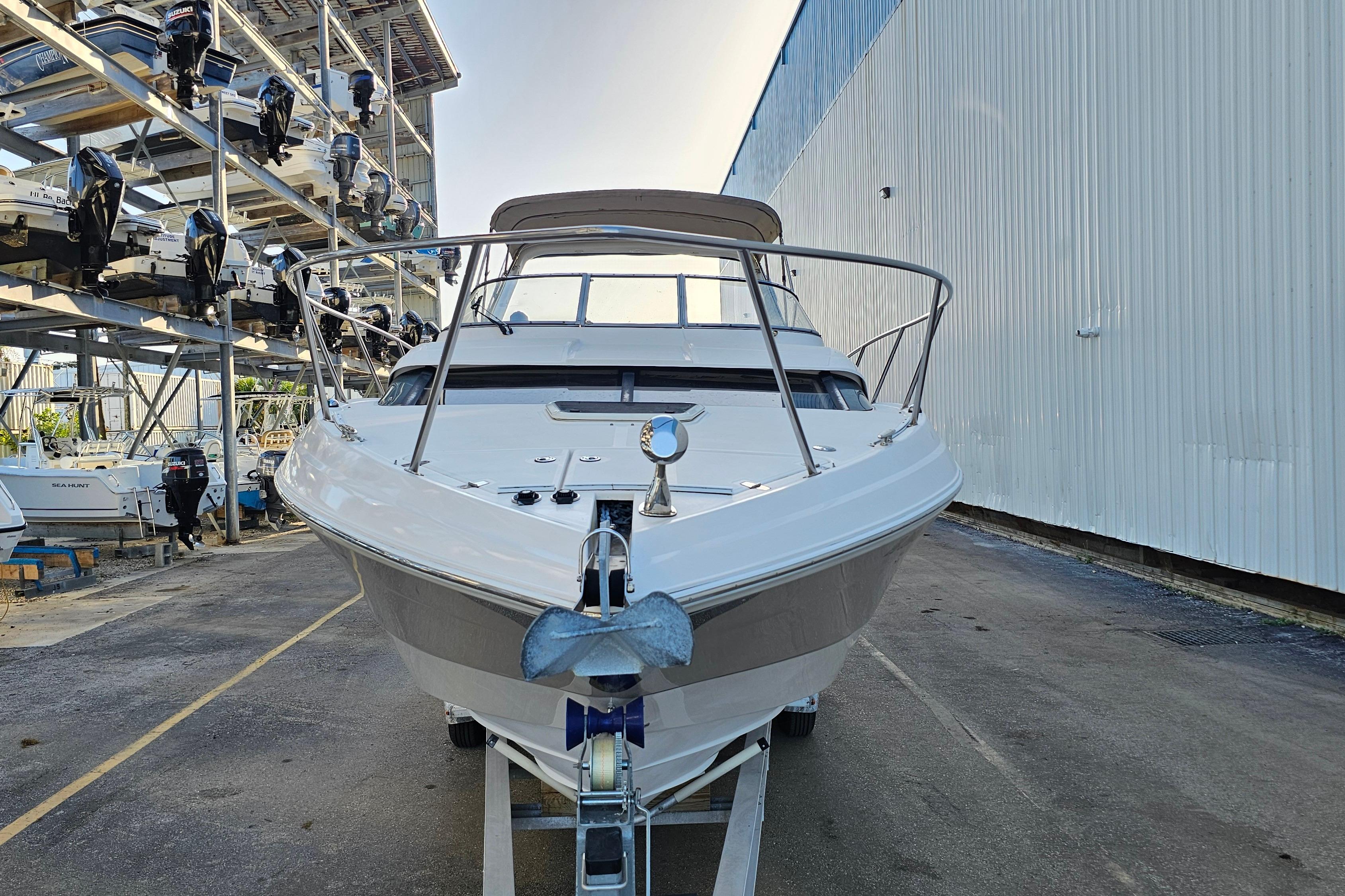 2005 Regal 3060 Window Express boat in storage, front view with marina backdrop.