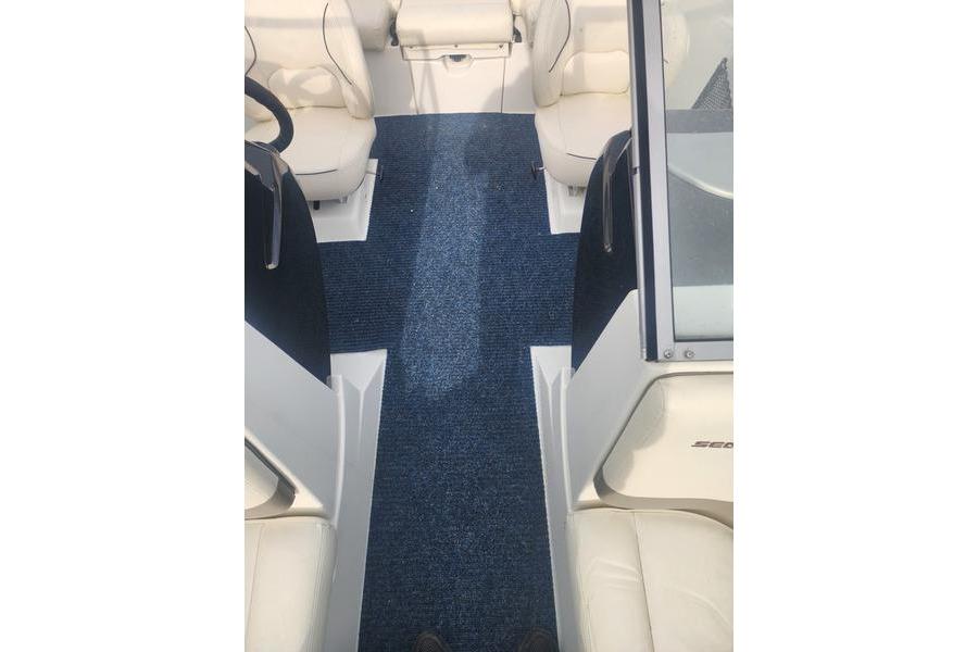 2012 Sea-Doo 180 Challenger interior with blue carpet and white seating.
