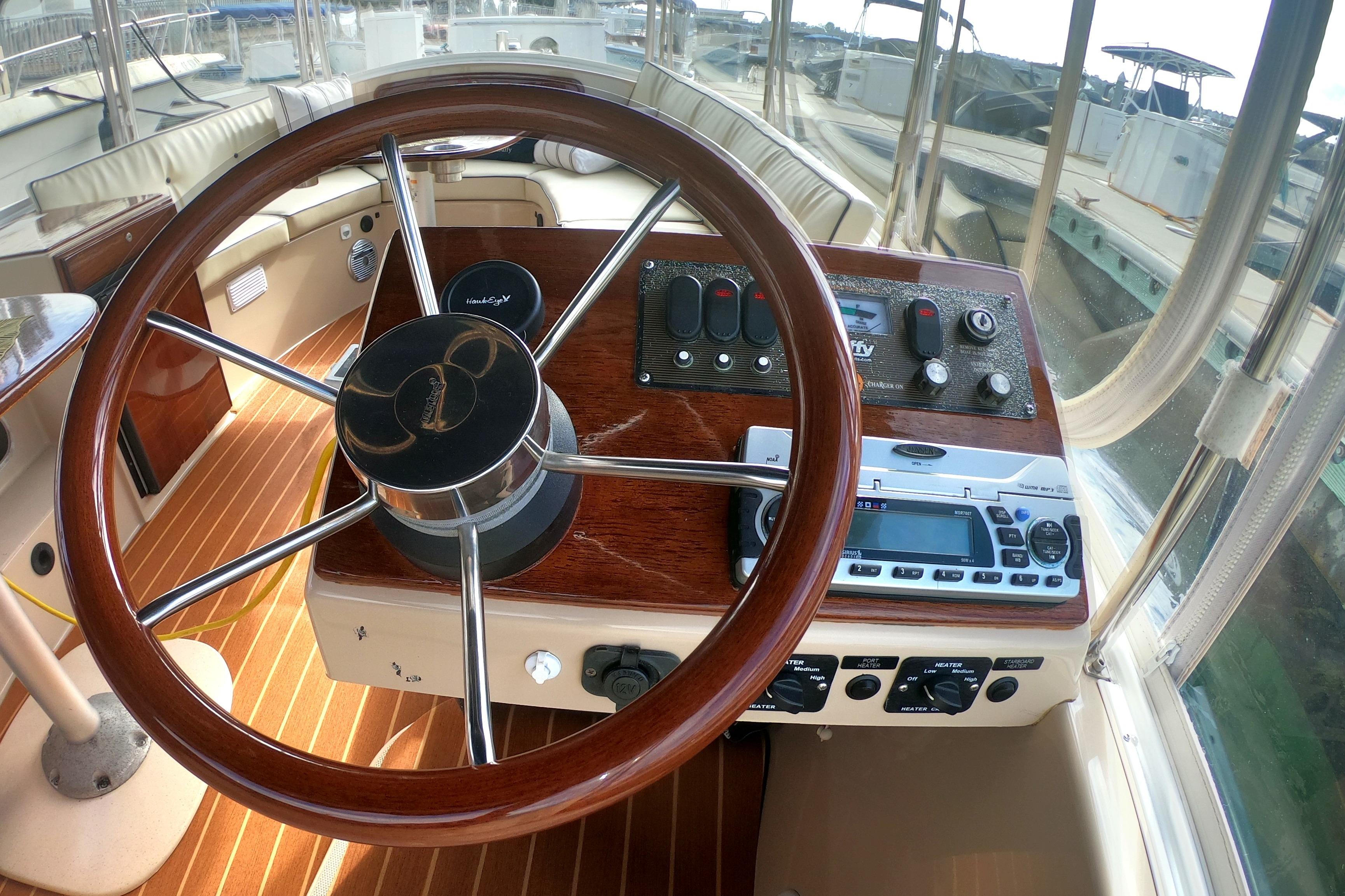 Interior view of 2008 Duffy Snug Harbor 18 boat cockpit with wooden steering wheel.