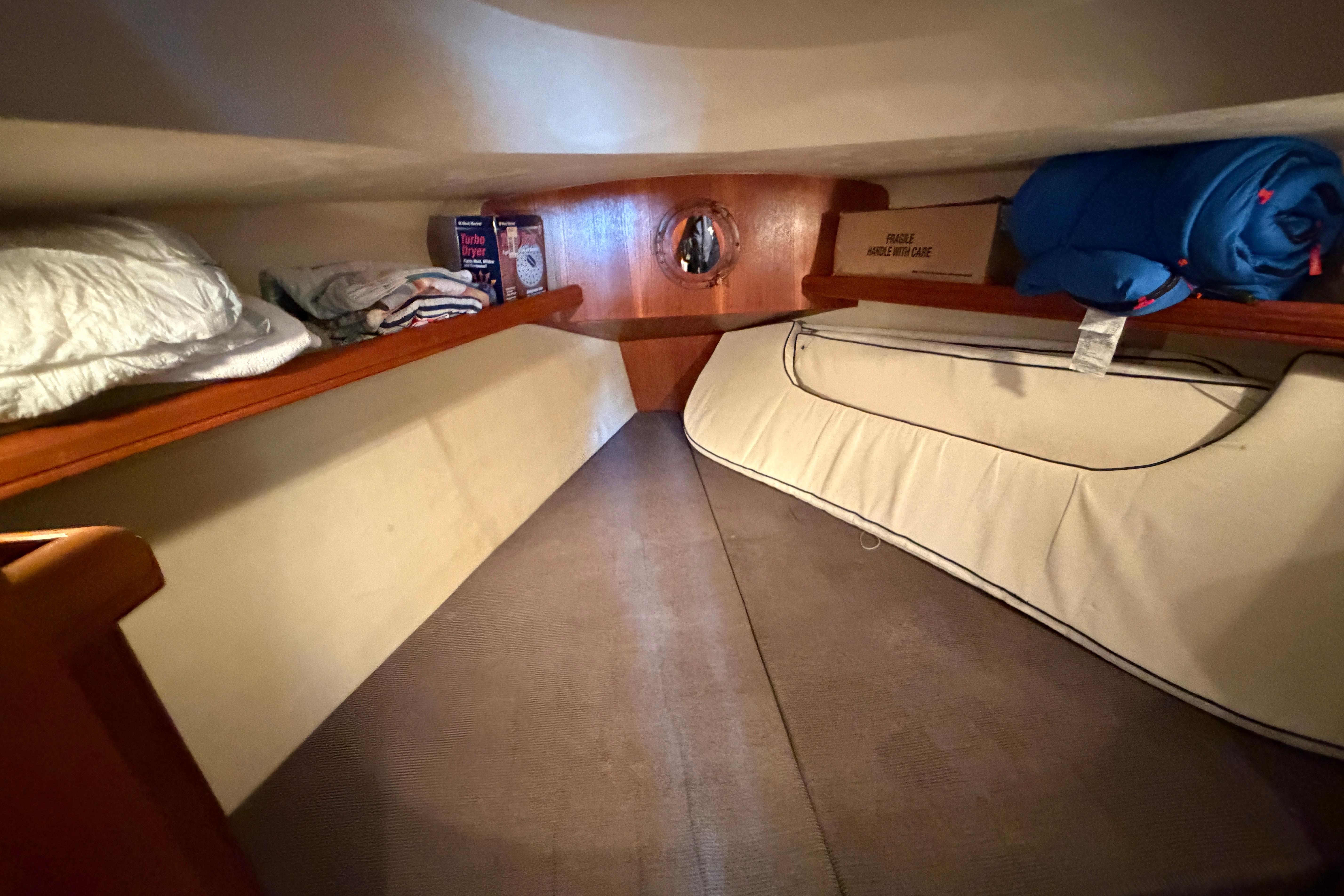 Interior cabin of a 2005 Hunter 38 sailboat with storage and bedding.