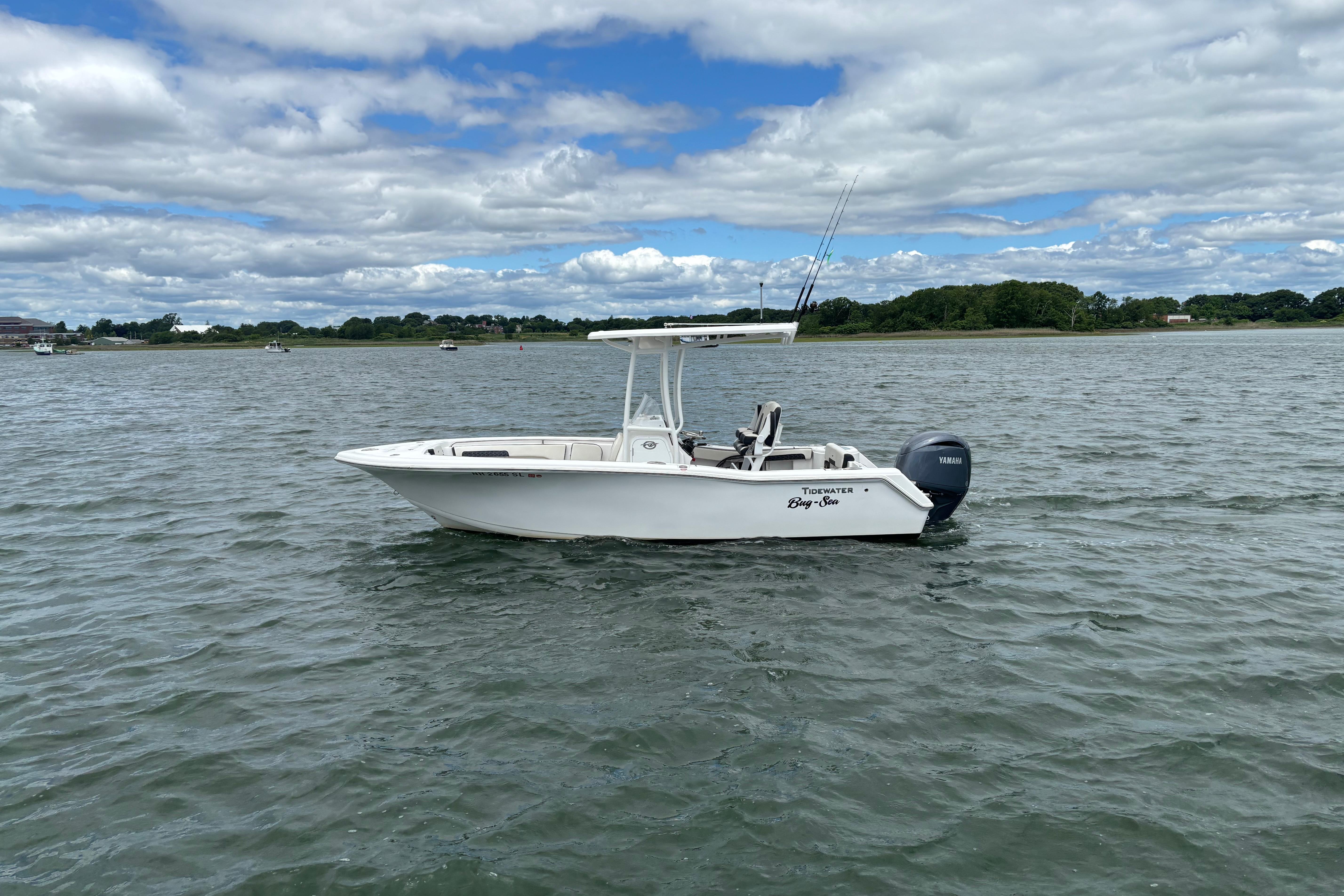 2024 Tidewater 220 CC Adventure boat on calm water under cloudy sky.