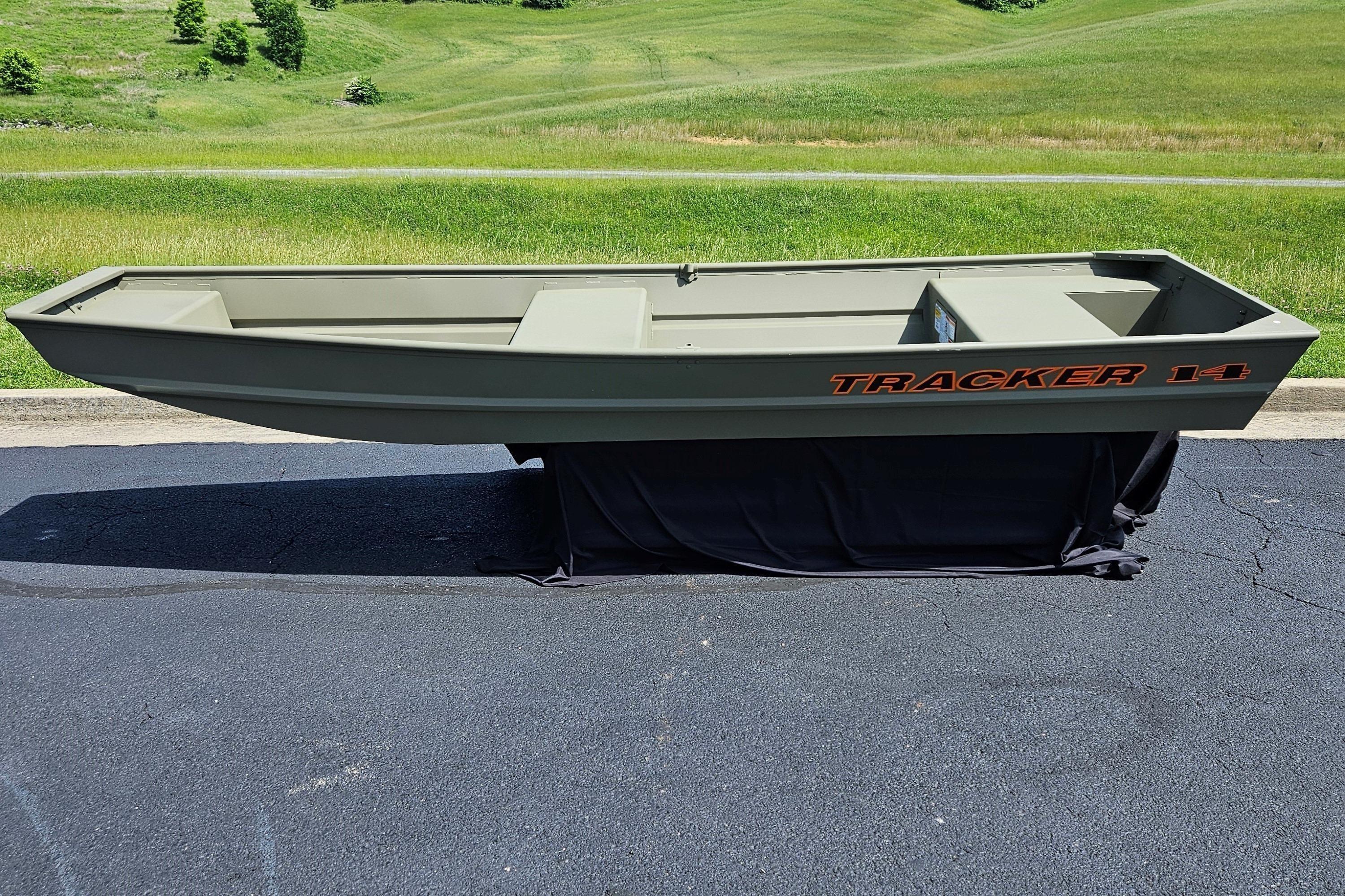 2026 Tracker Grizzly 14 Jon boat on pavement, green landscape background.