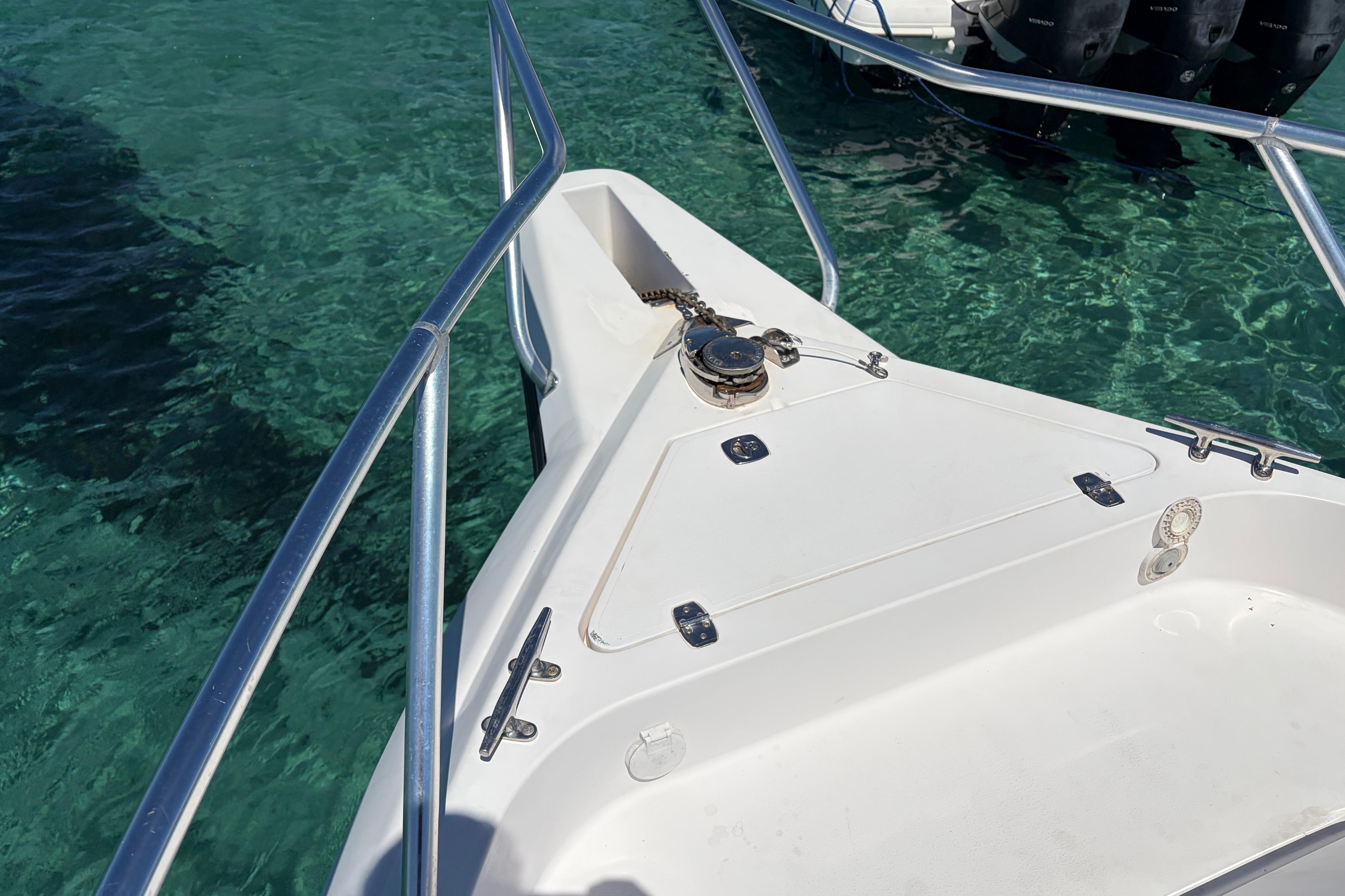 Bow of 1998 Intrepid 339 Walkaround boat on clear turquoise water.