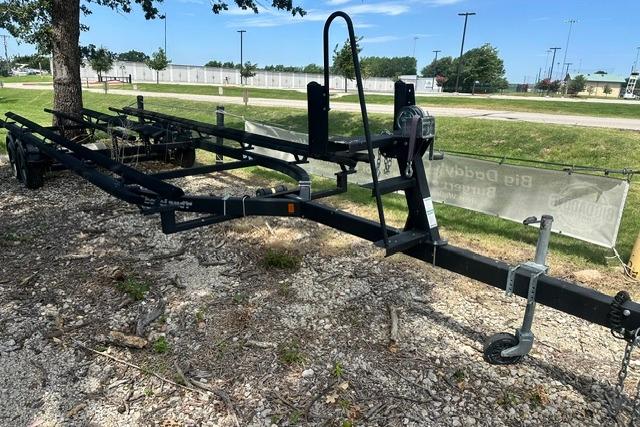 Trailer for 2021 Bennington L Bowrider 25 Quad Bench, parked on gravel near trees.