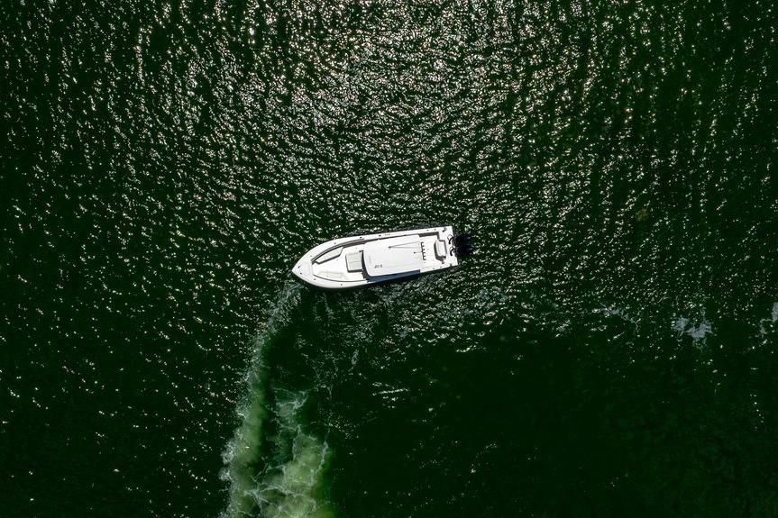 Aerial view of 2027 Reef Runner 340 boat on shimmering green water.