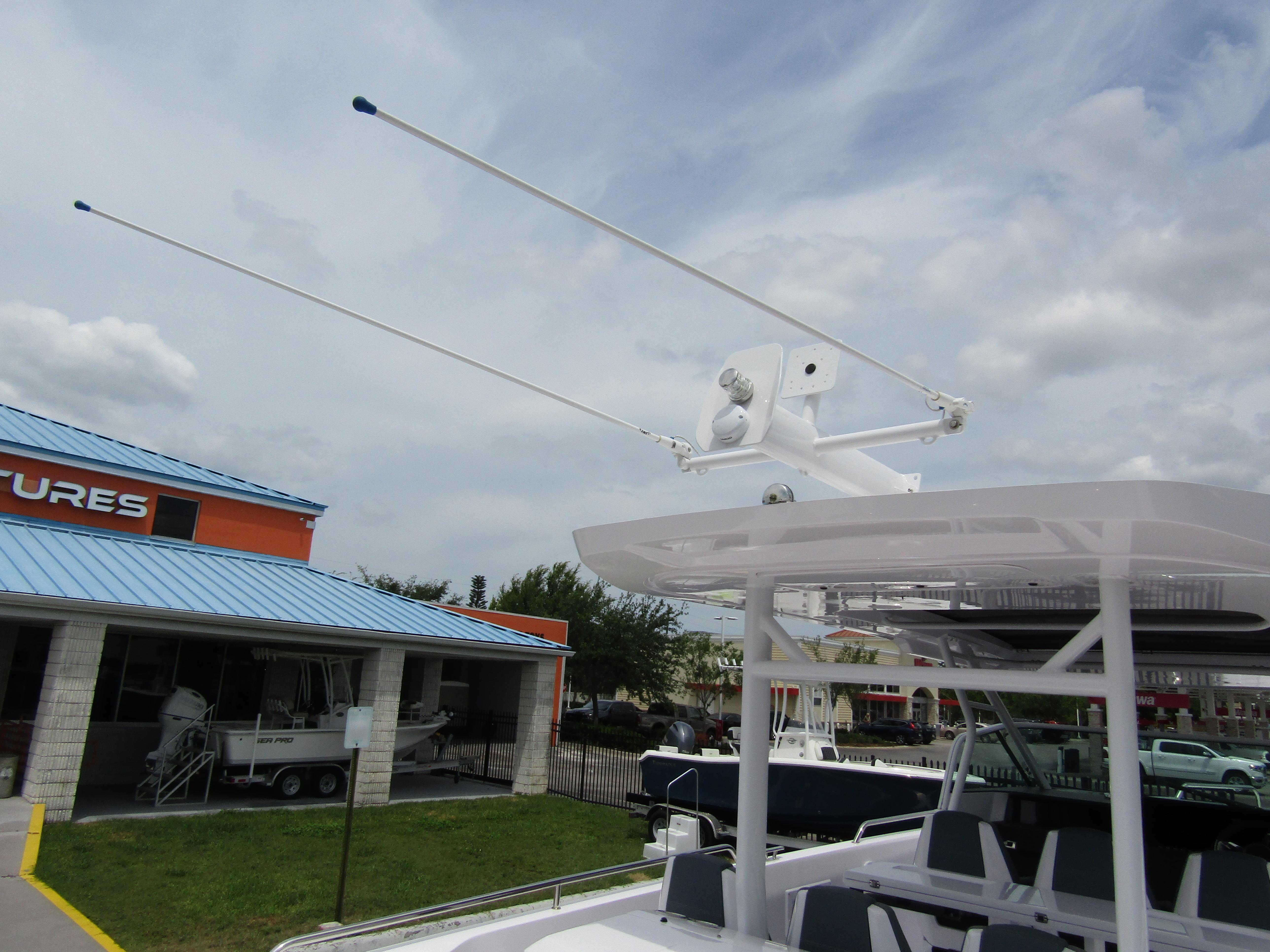 2024 Axopar 37 Sun Top boat with radar and antennas, docked near a building.