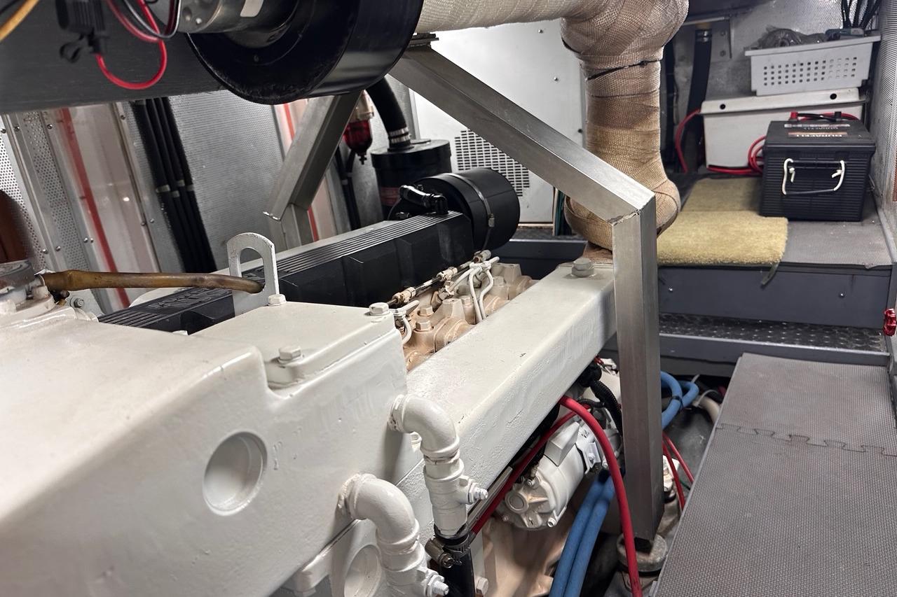 Engine room of a 1998 Nordhavn 46 yacht, showcasing mechanical components and storage.