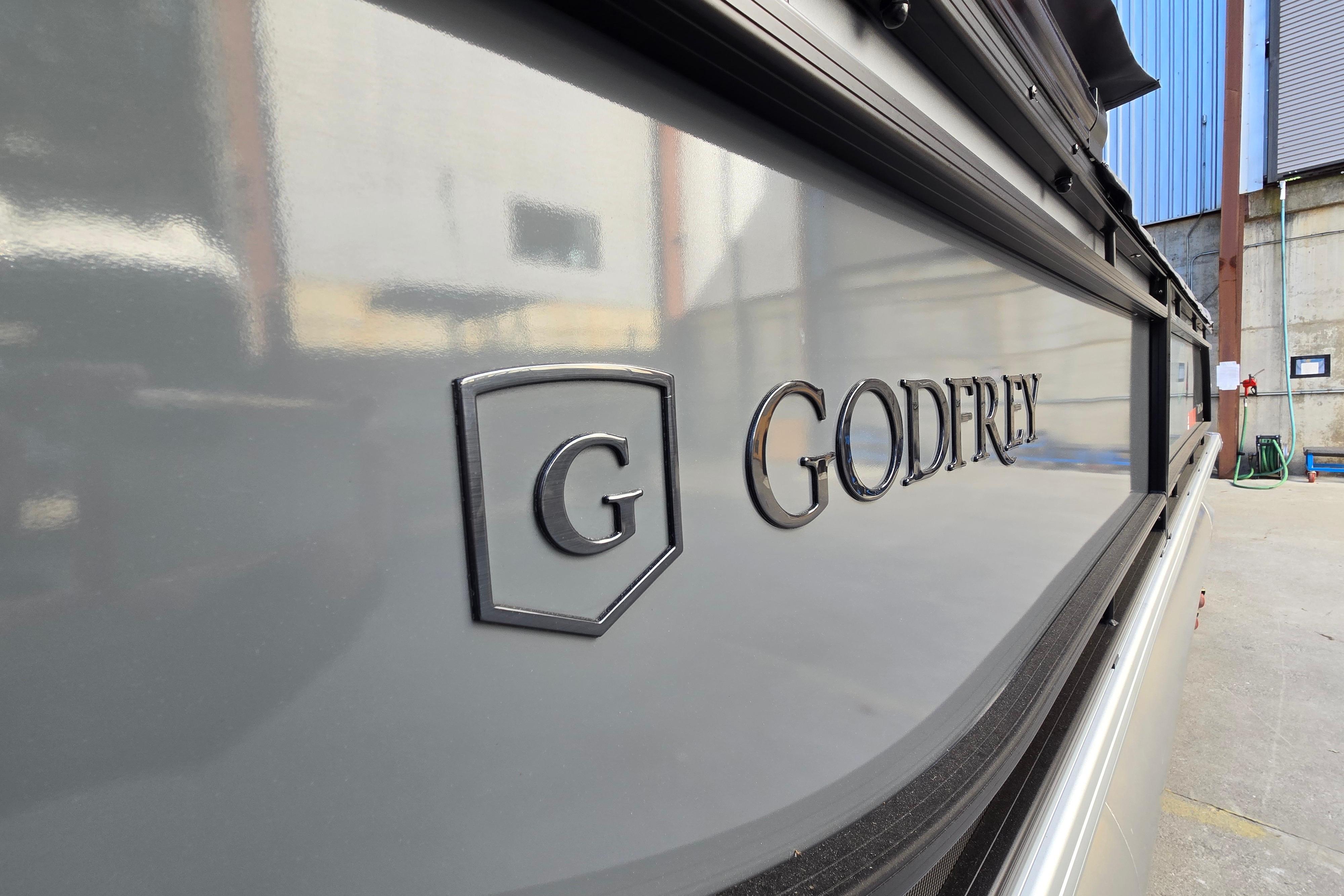 2024 Godfrey Sweetwater 2486 SB boat with logo detail in a marina setting.
