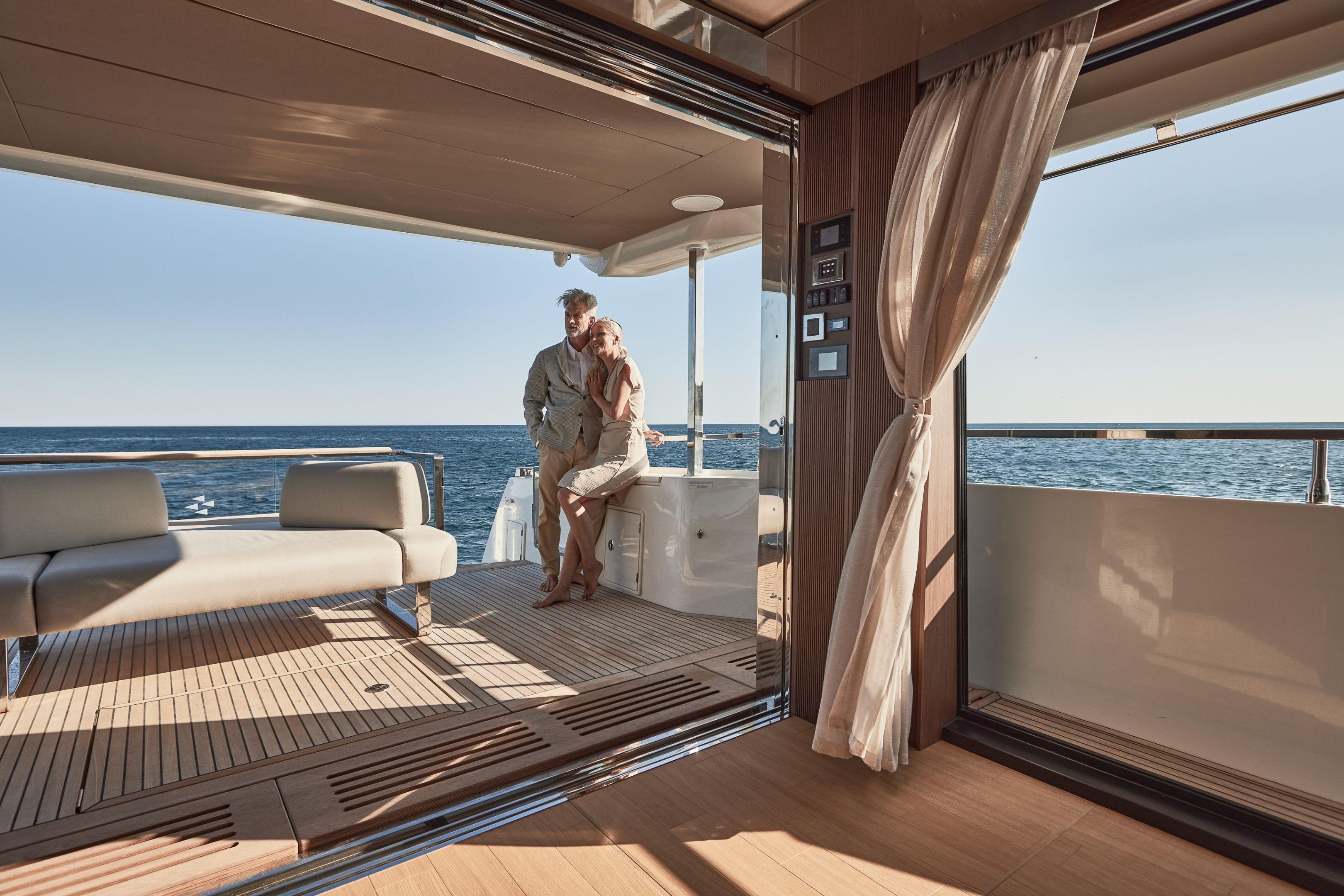 Couple enjoying luxury on 2026 Prestige X60 yacht deck with ocean view.