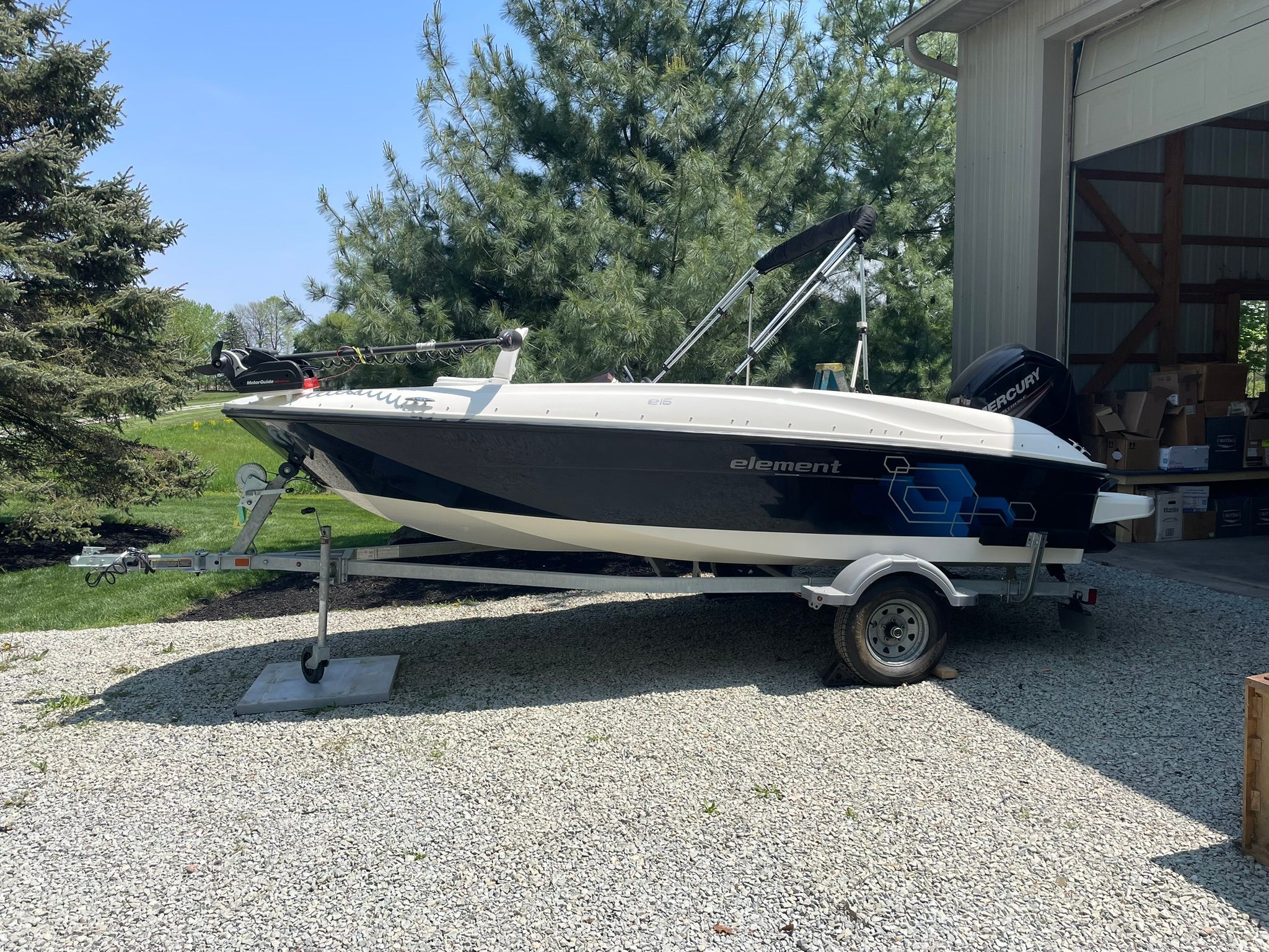 A 2018 Bayliner 160 Bowrider on a trailer beside a building.