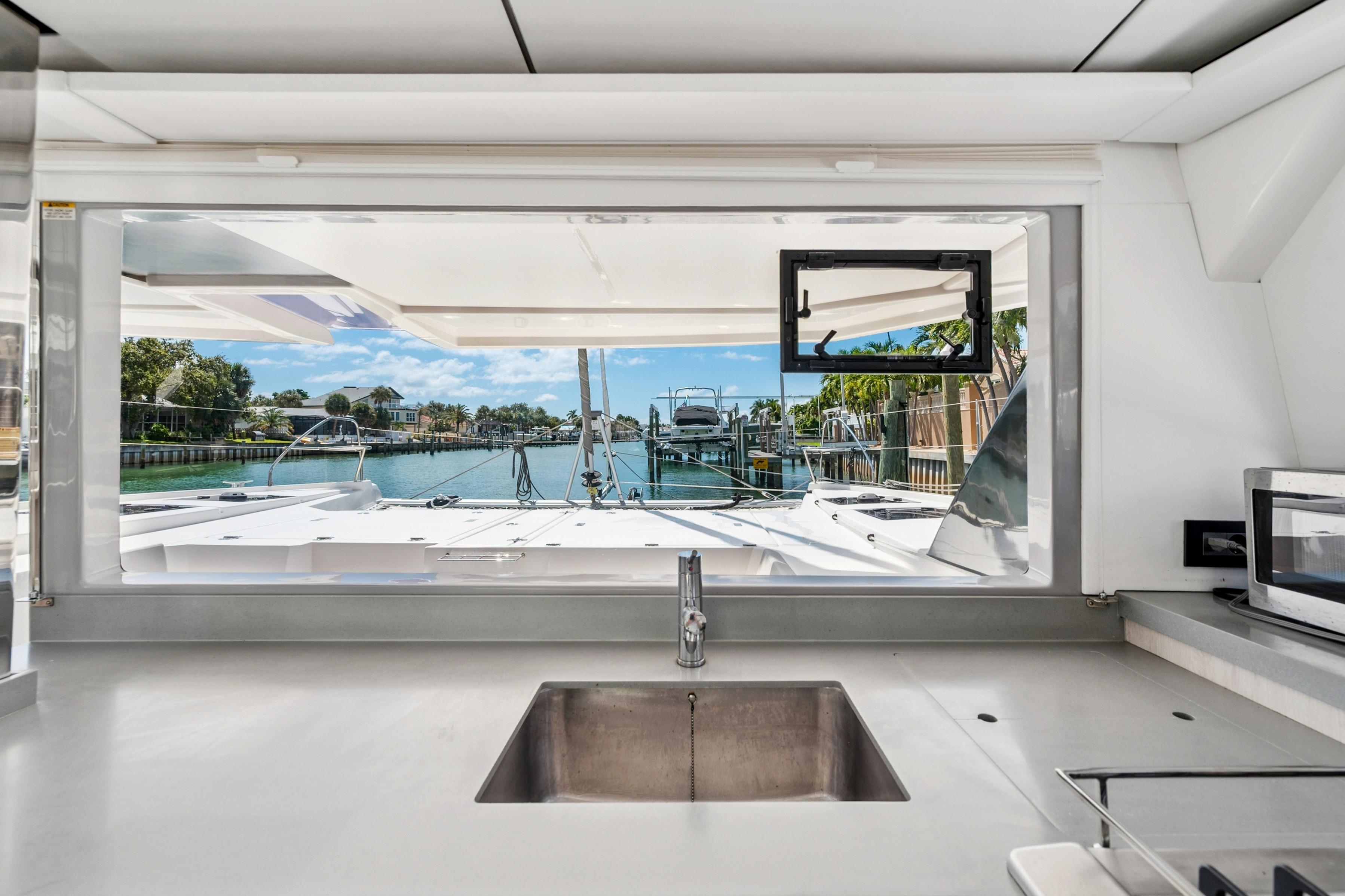 Interior view from a 2021 Leopard 45 yacht, showcasing a sleek kitchen and scenic marina.