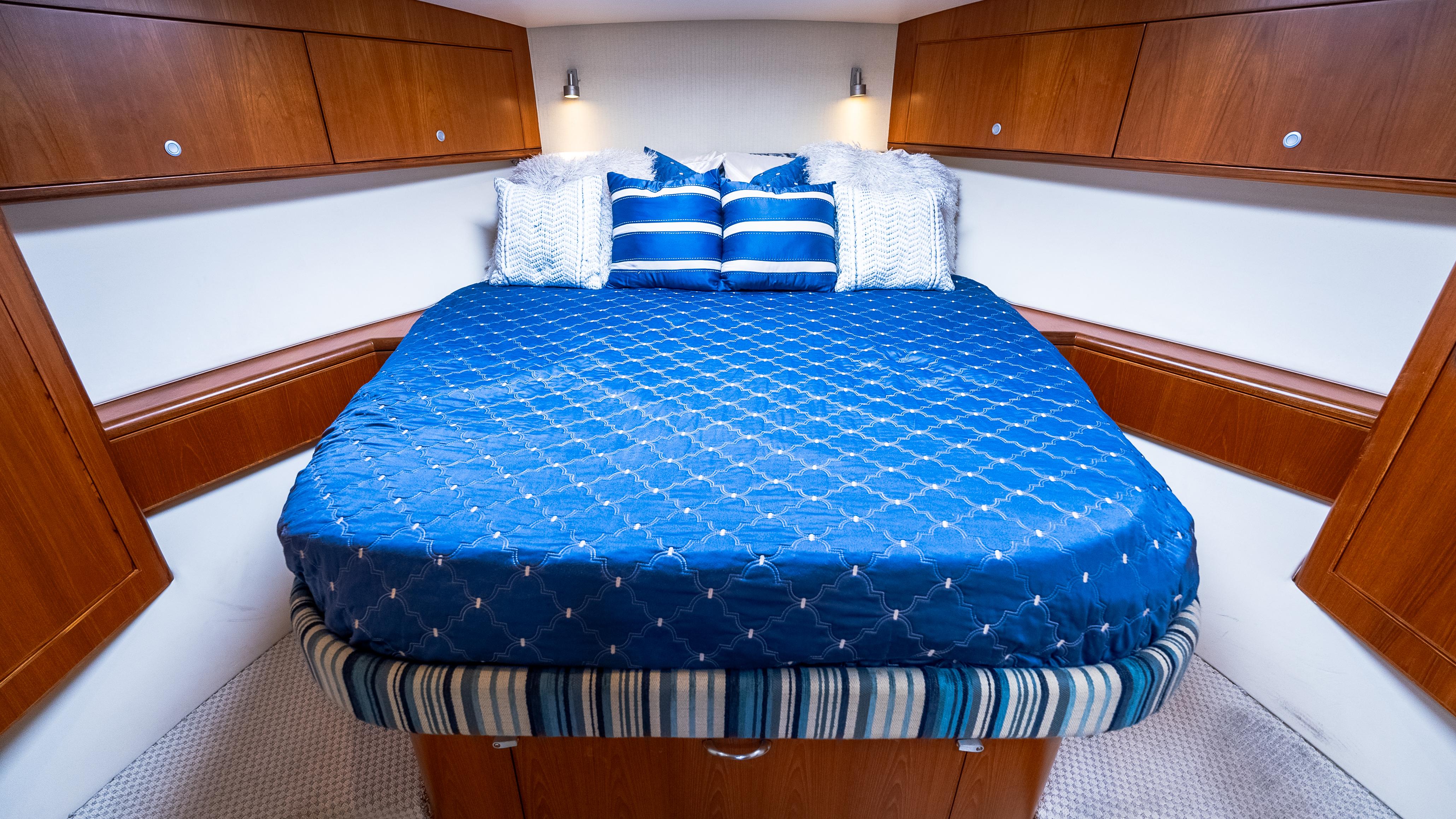 Luxurious cabin interior of 2012 Cabo 44 HTX yacht with blue bedding.
