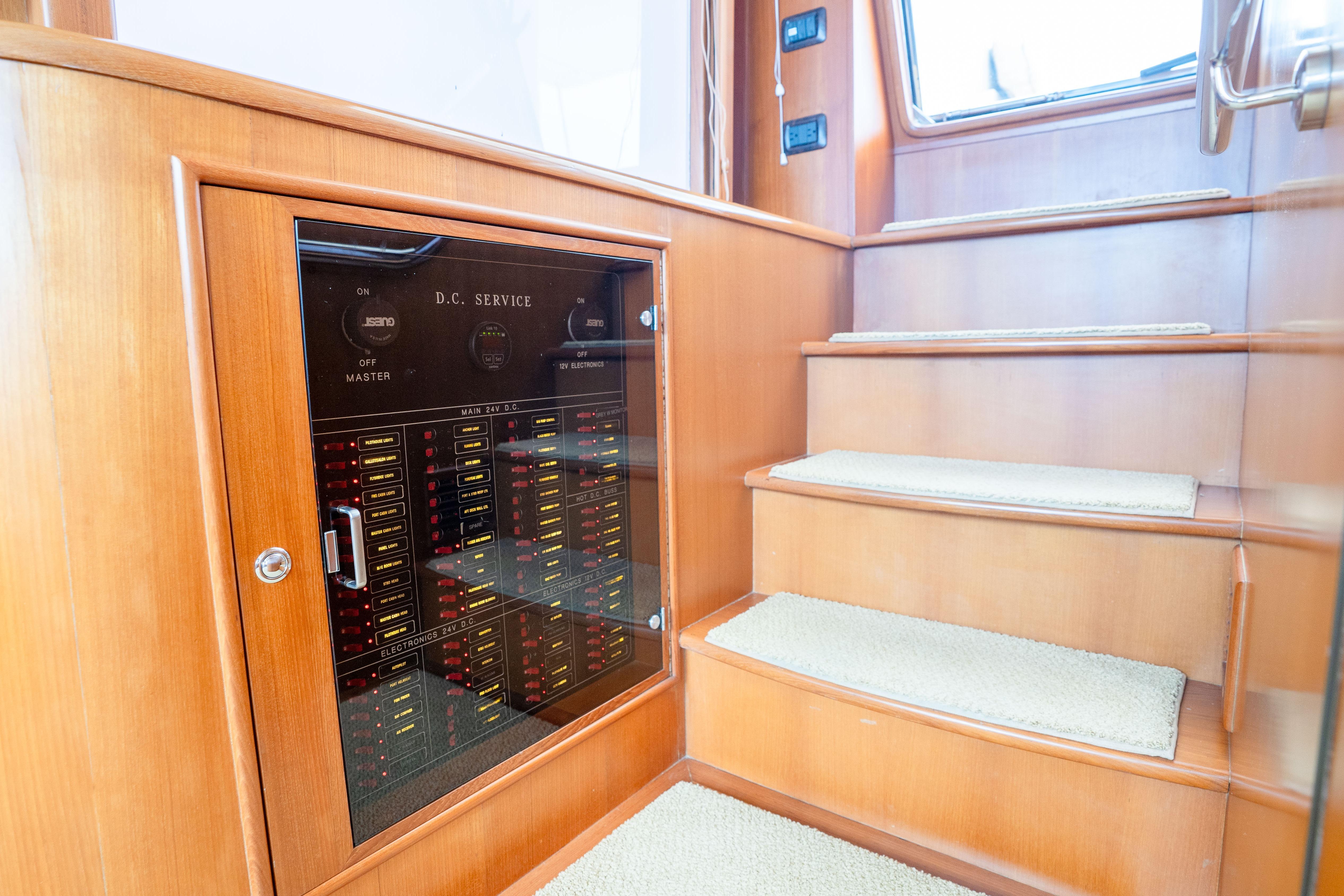 Interior of 2006 Fleming 75 yacht showing DC service panel and wooden stairs.