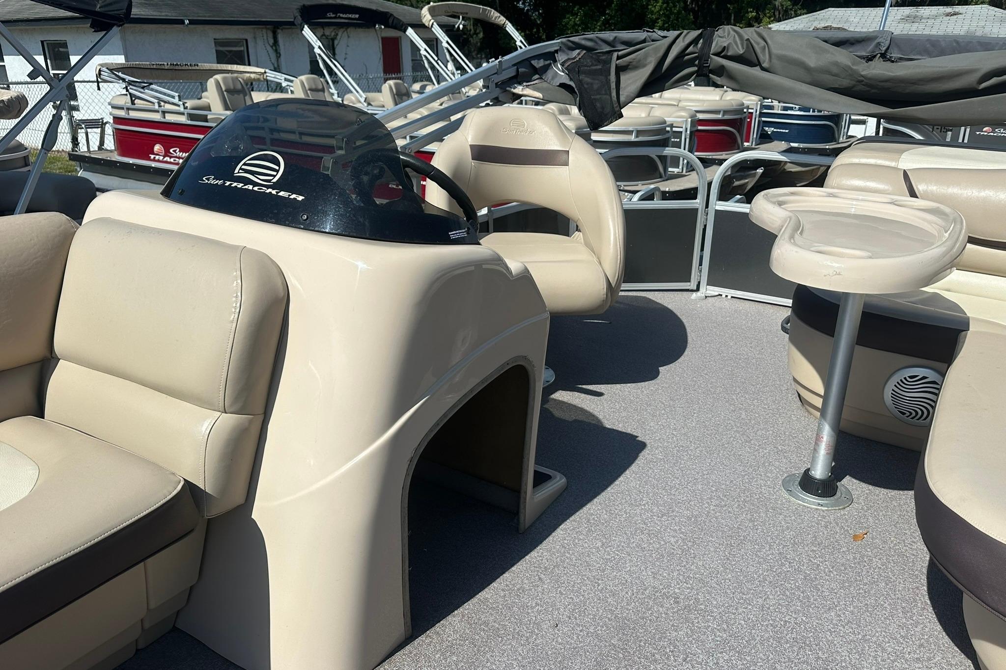 2016 SUNTRACKER Party Barge 20 interior with beige seating and helm.