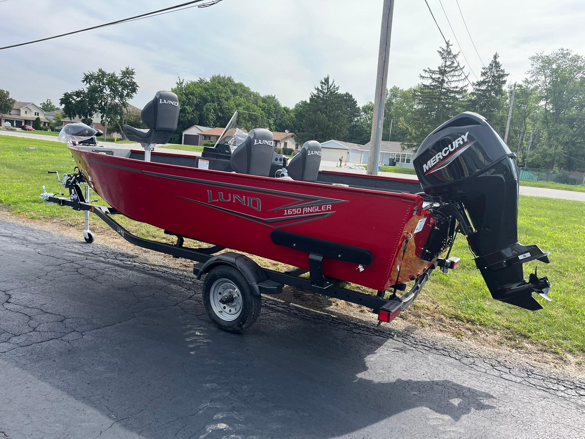 2026 Lund 1650 Angler SS boat with Mercury engine on trailer, parked outdoors.