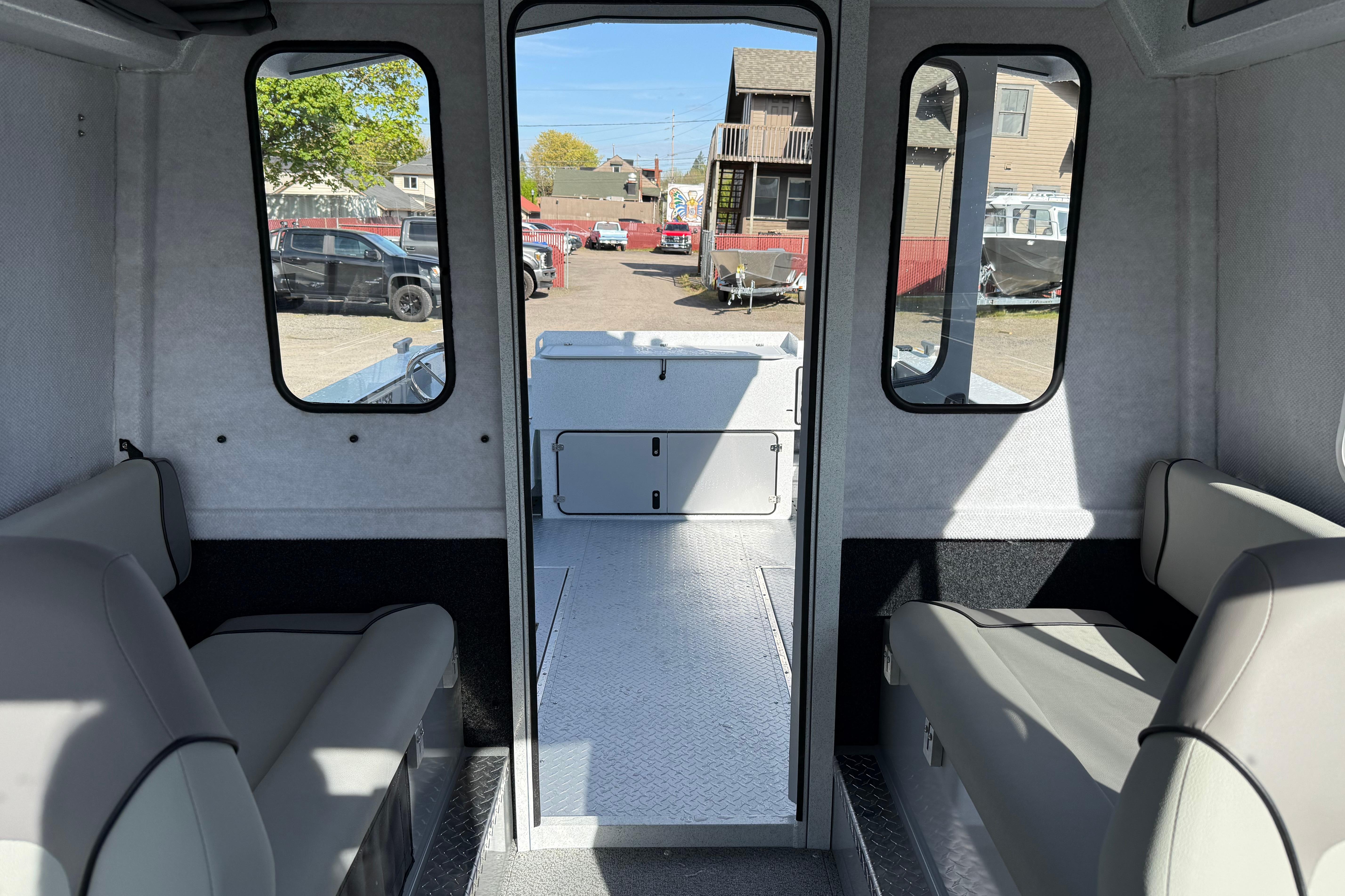 Interior of 2026 KingFisher 2425 Escape HT boat, featuring seating and windows.