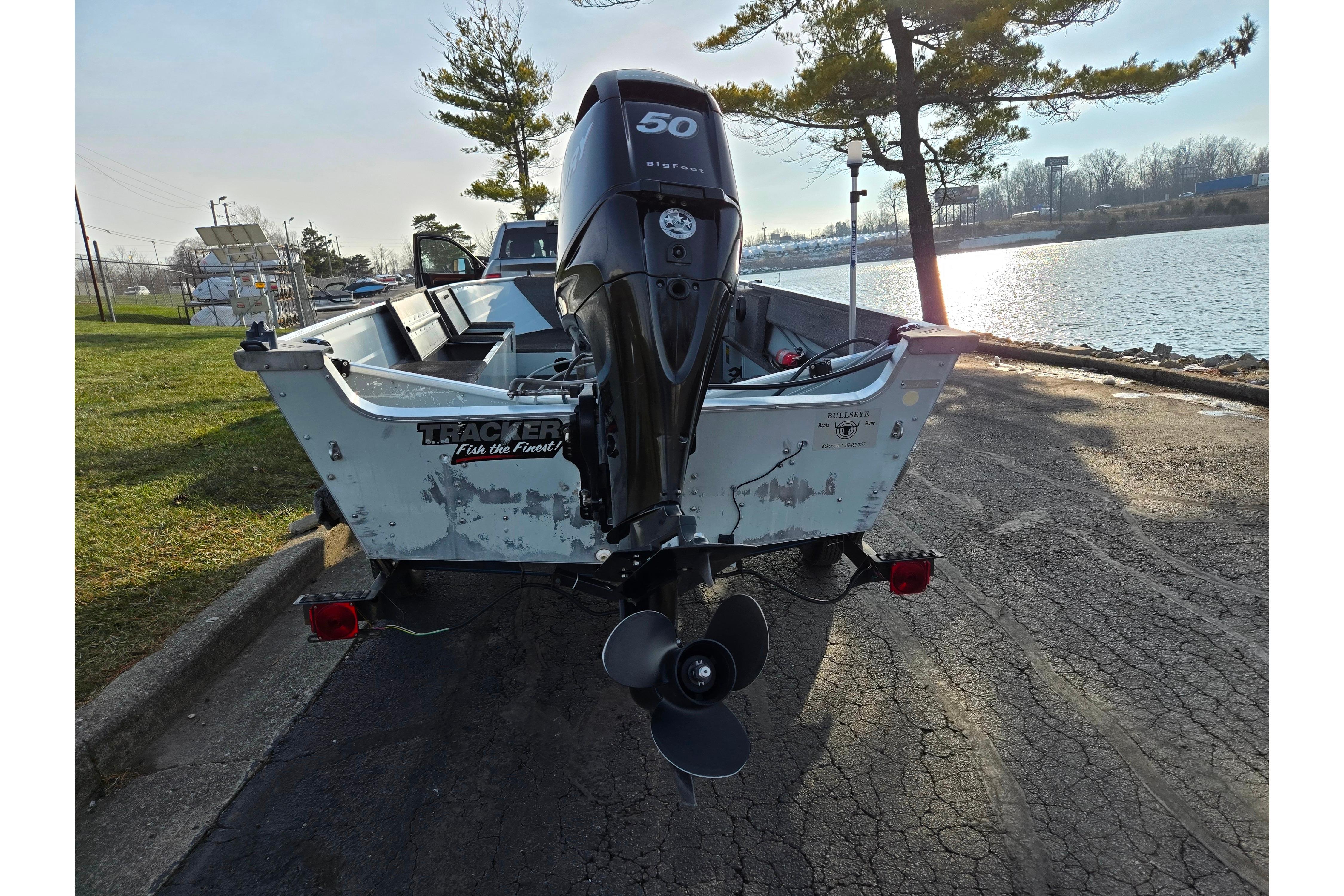 1994 Tracker Pro Deep V-16 boat with outboard motor by a lakeside.