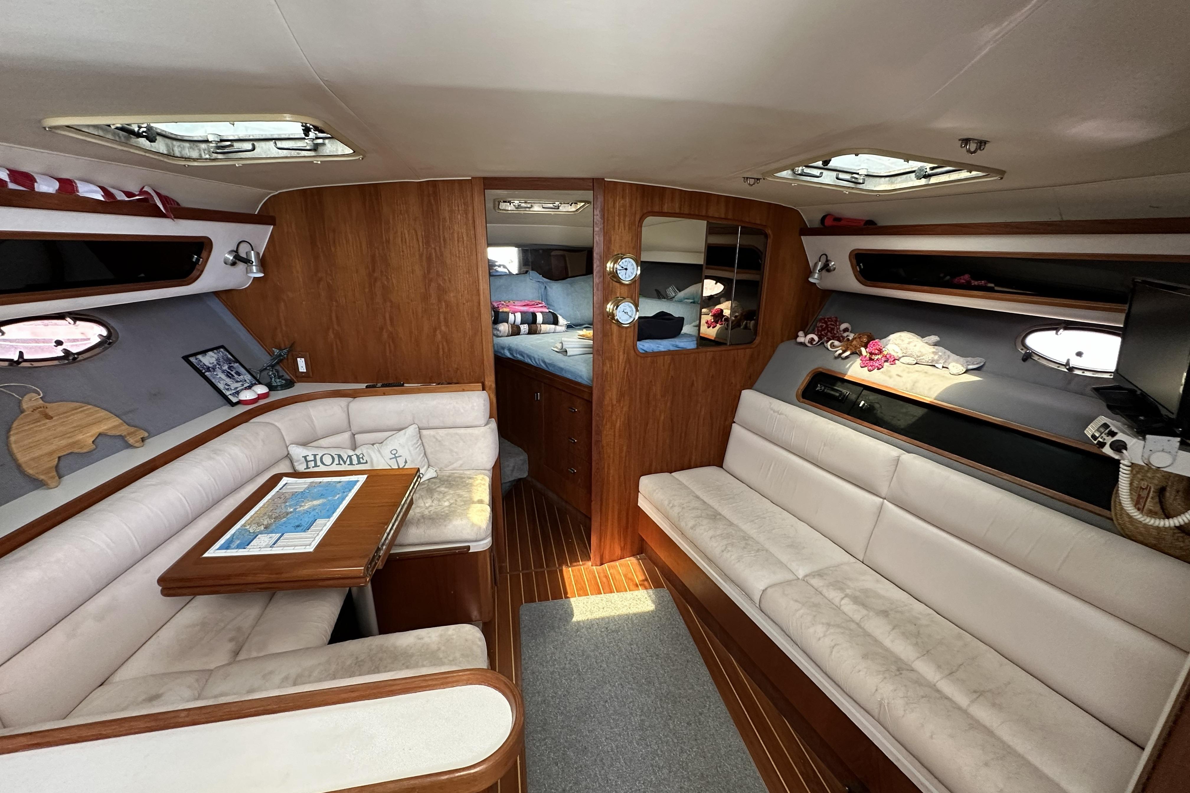 Luxurious interior of a 1990 Tiara Yachts 3600 Open, featuring cozy seating and elegant wood finishes.