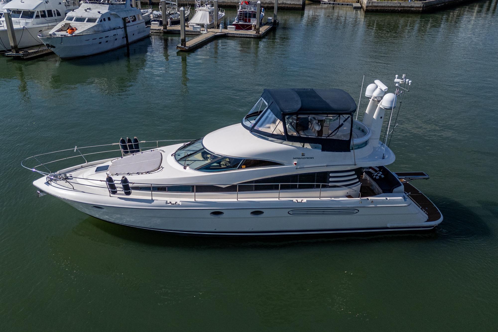 2000 Fairline Squadron 52 yacht docked in marina, side view.