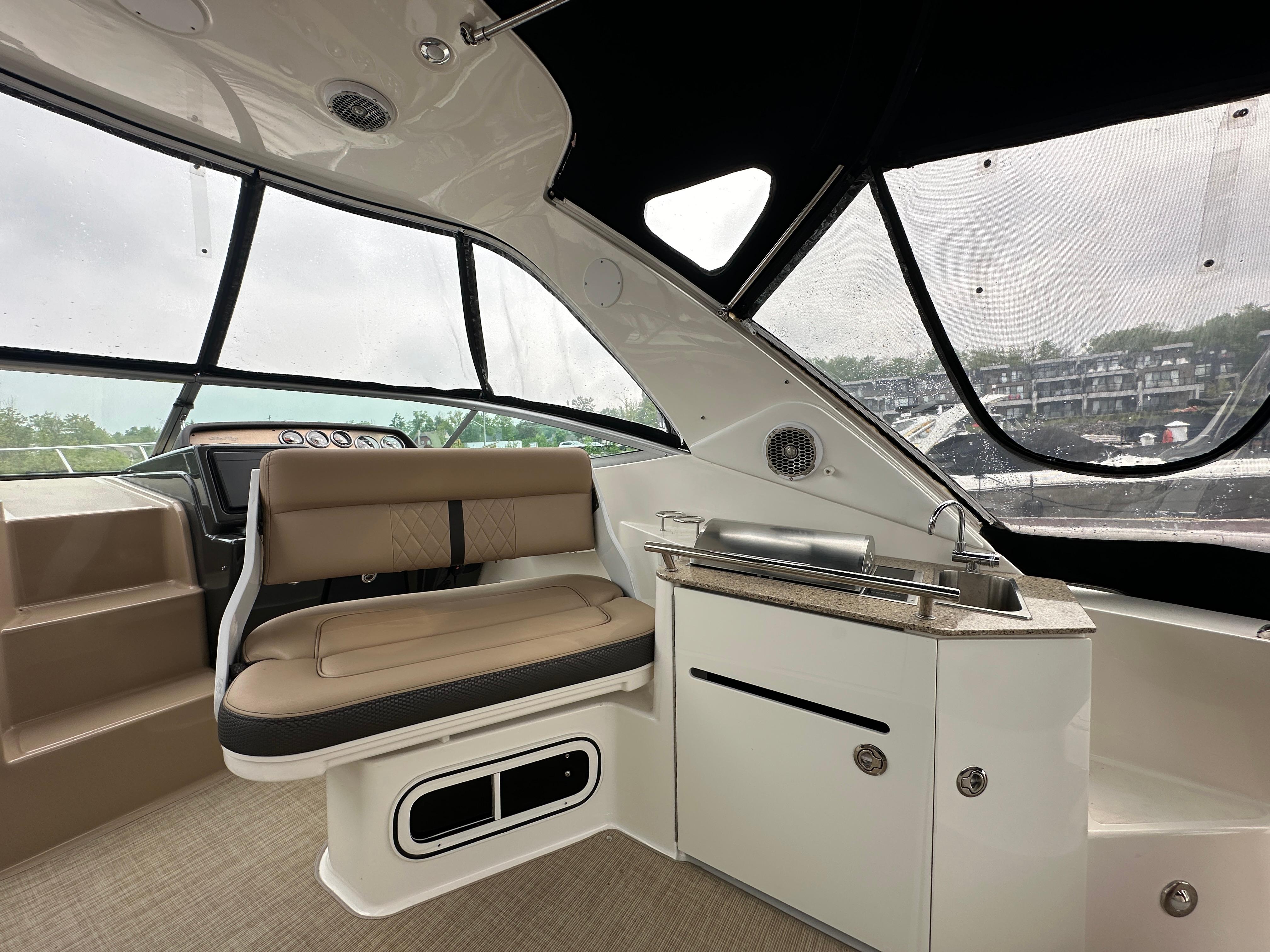 Interior of 2017 Sea Ray Sundancer 310 boat with seating and kitchenette.