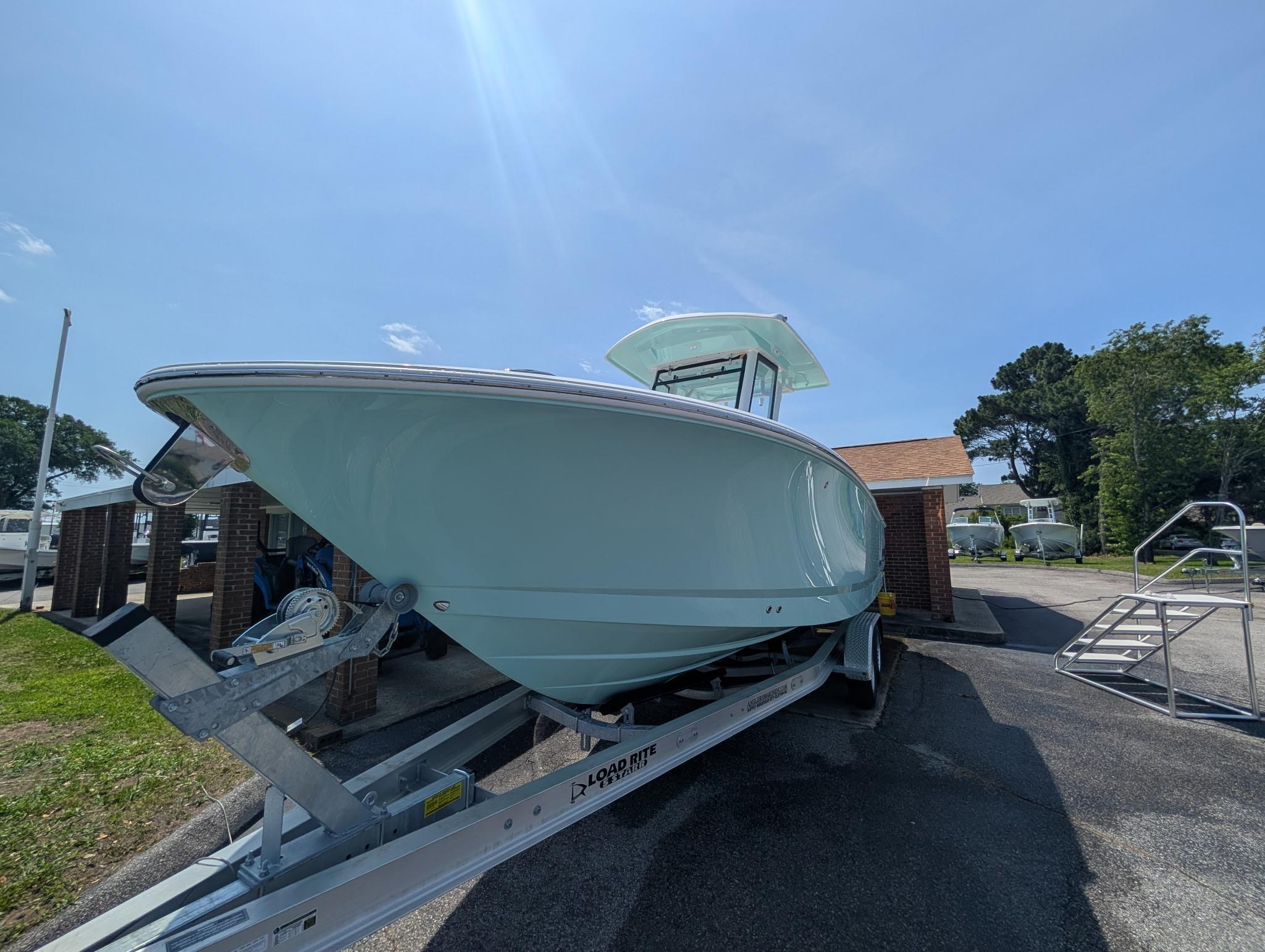 2025 Robalo R250 Center Console boat on trailer under clear blue sky.