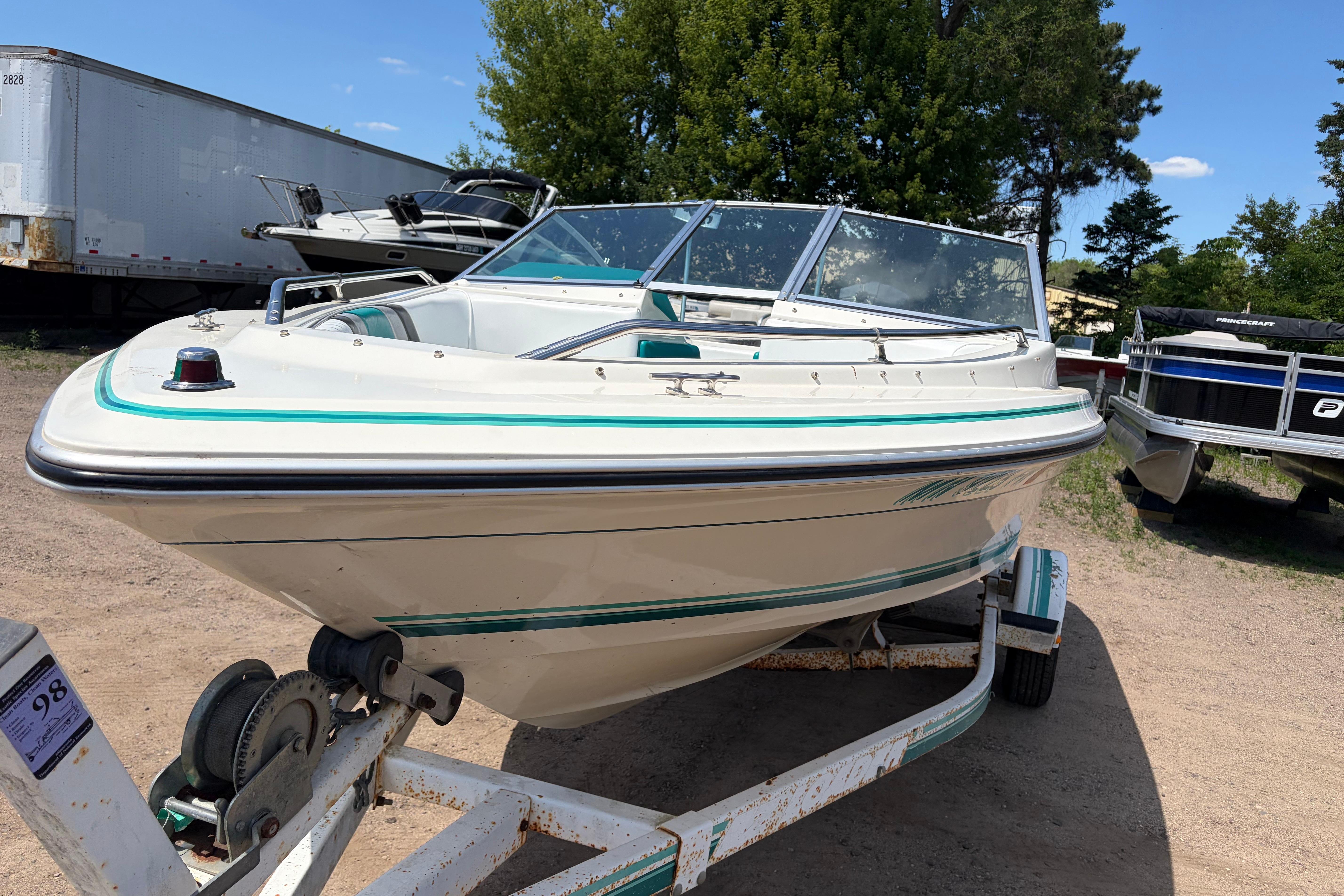 1990 Sea Ray 180 Bow Rider boat on trailer, parked outdoors on a sunny day.