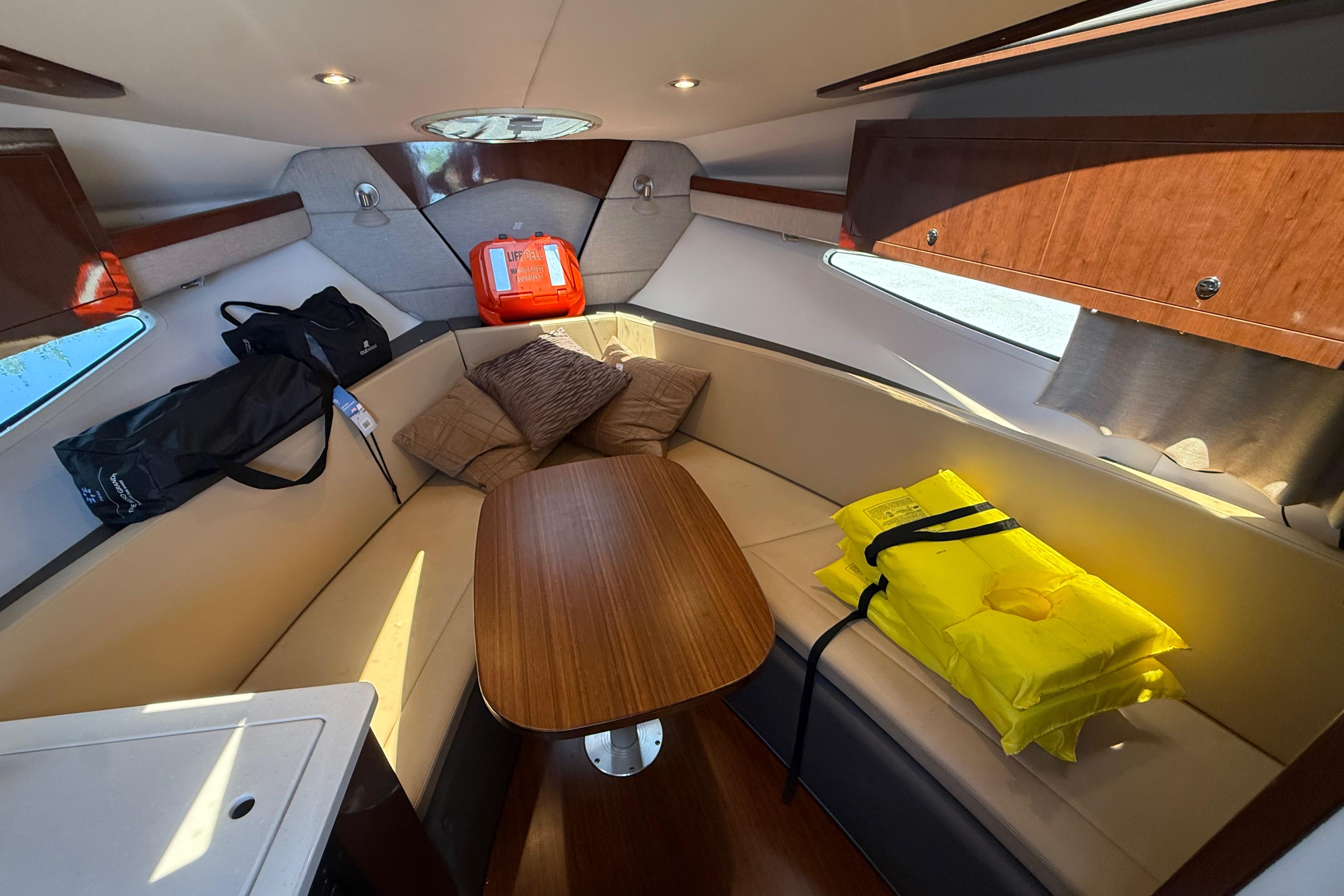 Interior of 2017 Four Winns V275 boat with seating, table, and safety equipment.