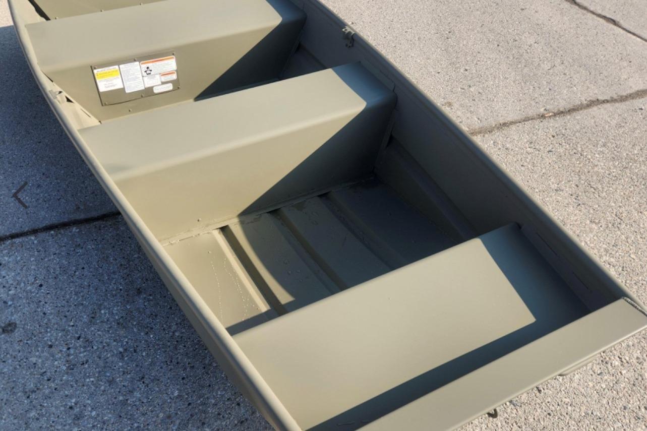 2026 Tracker Grizzly 10 Jon boat on concrete surface, showcasing interior seating and structure.