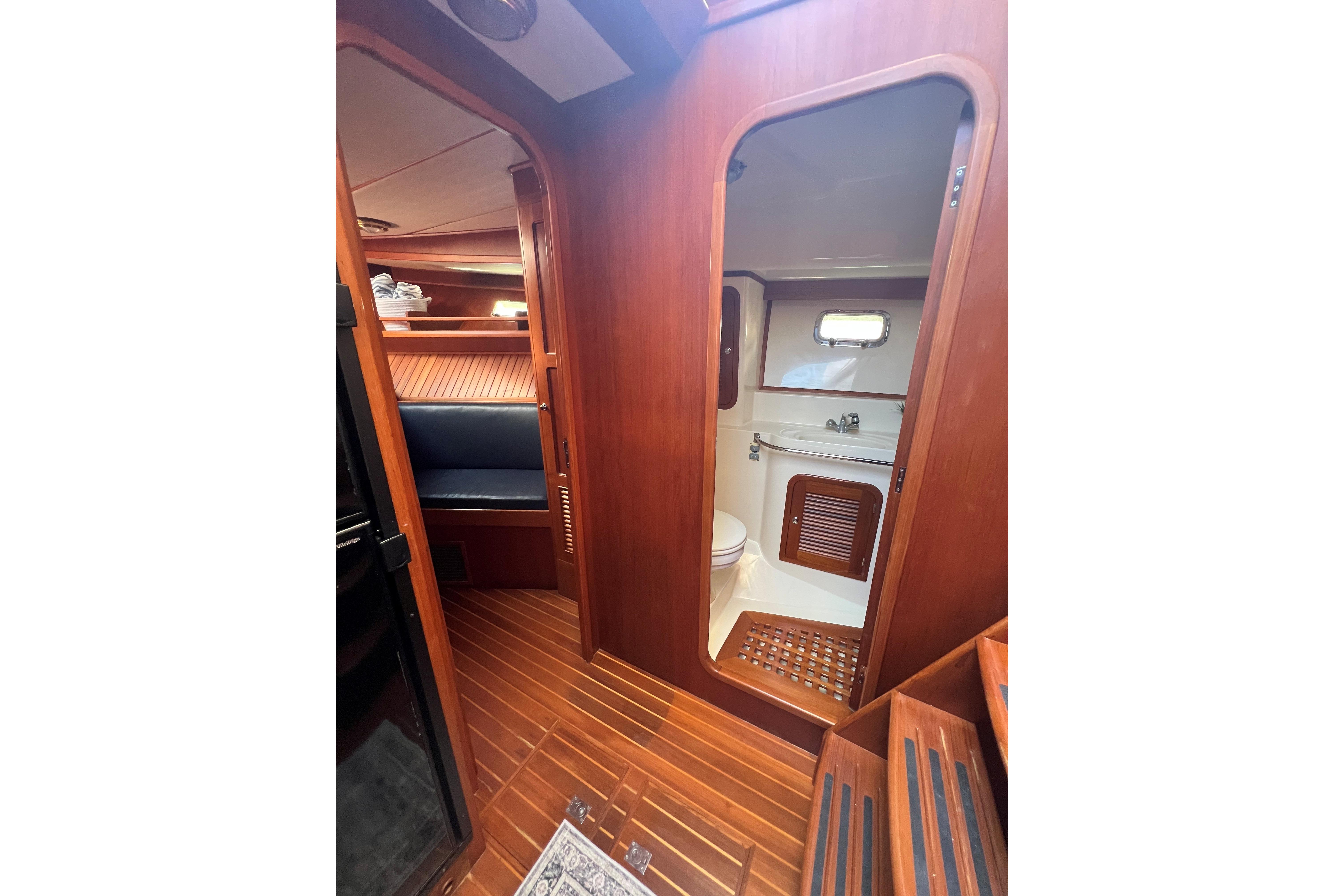Interior of 2007 Heritage East 36 Sundeck Trawler with wooden finish and compact bathroom.