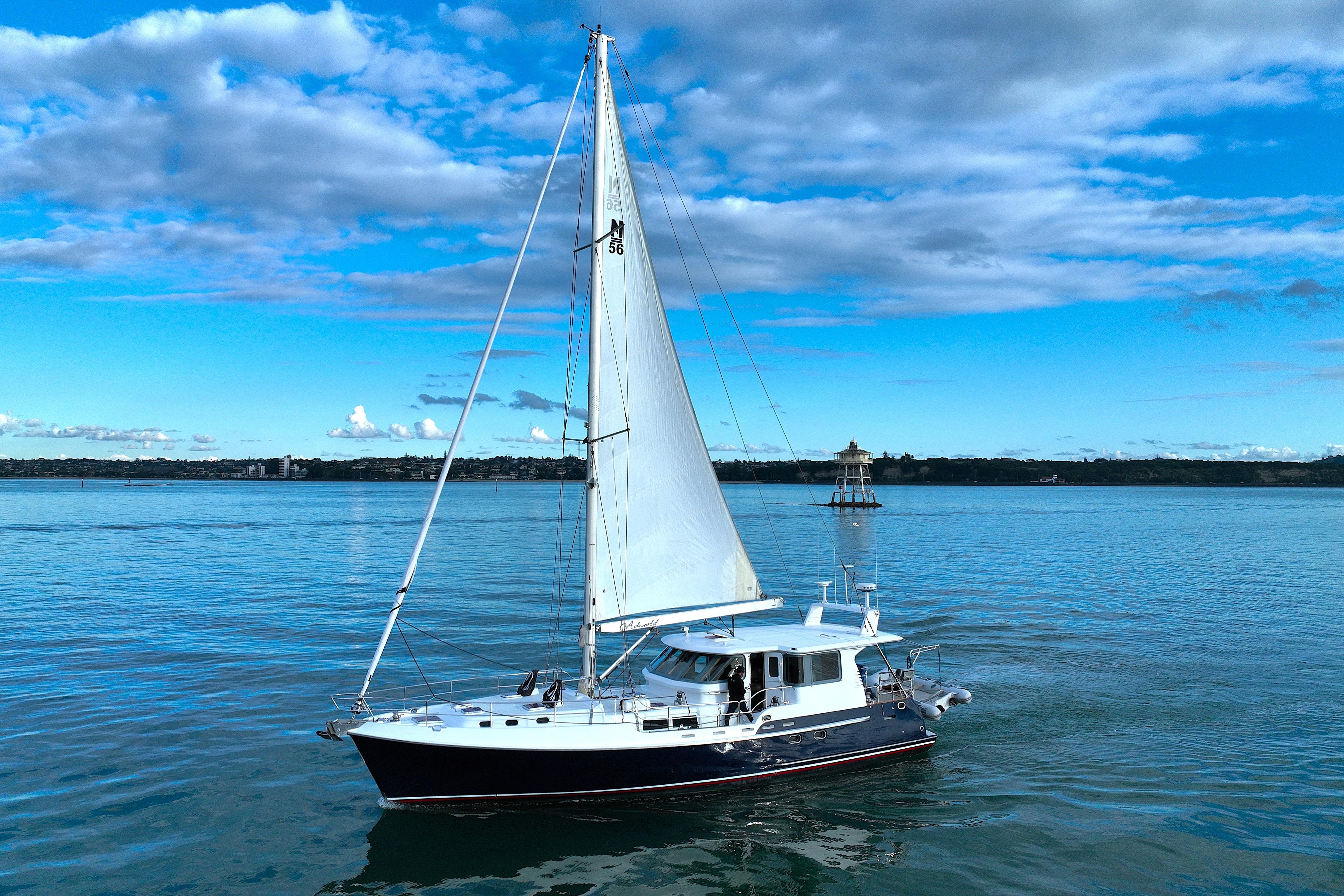 2009 Nordhavn 56 Motorsailer sailing on calm waters under a blue sky.
