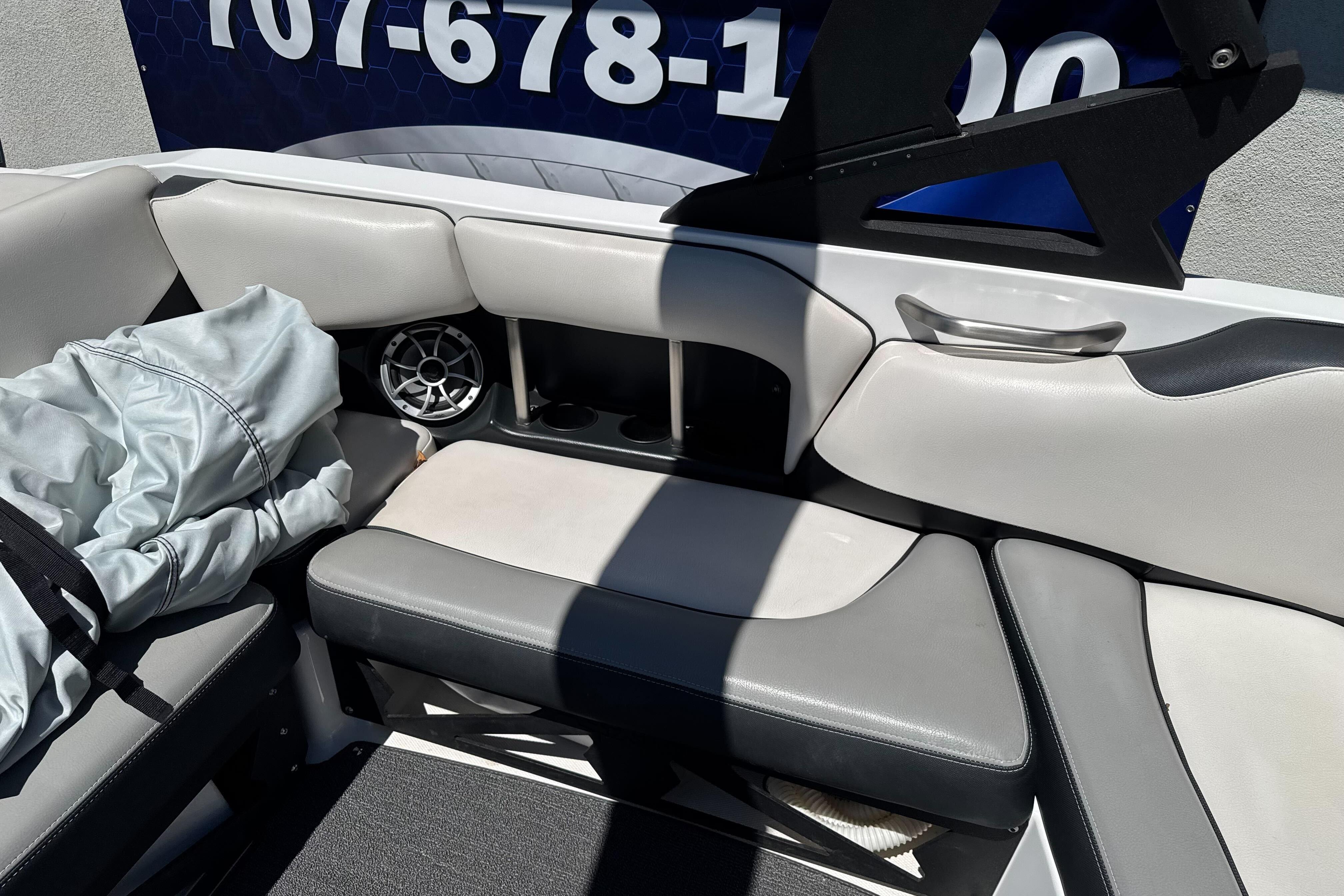 Interior of a 2015 Axis A20 boat with gray seating and speaker.