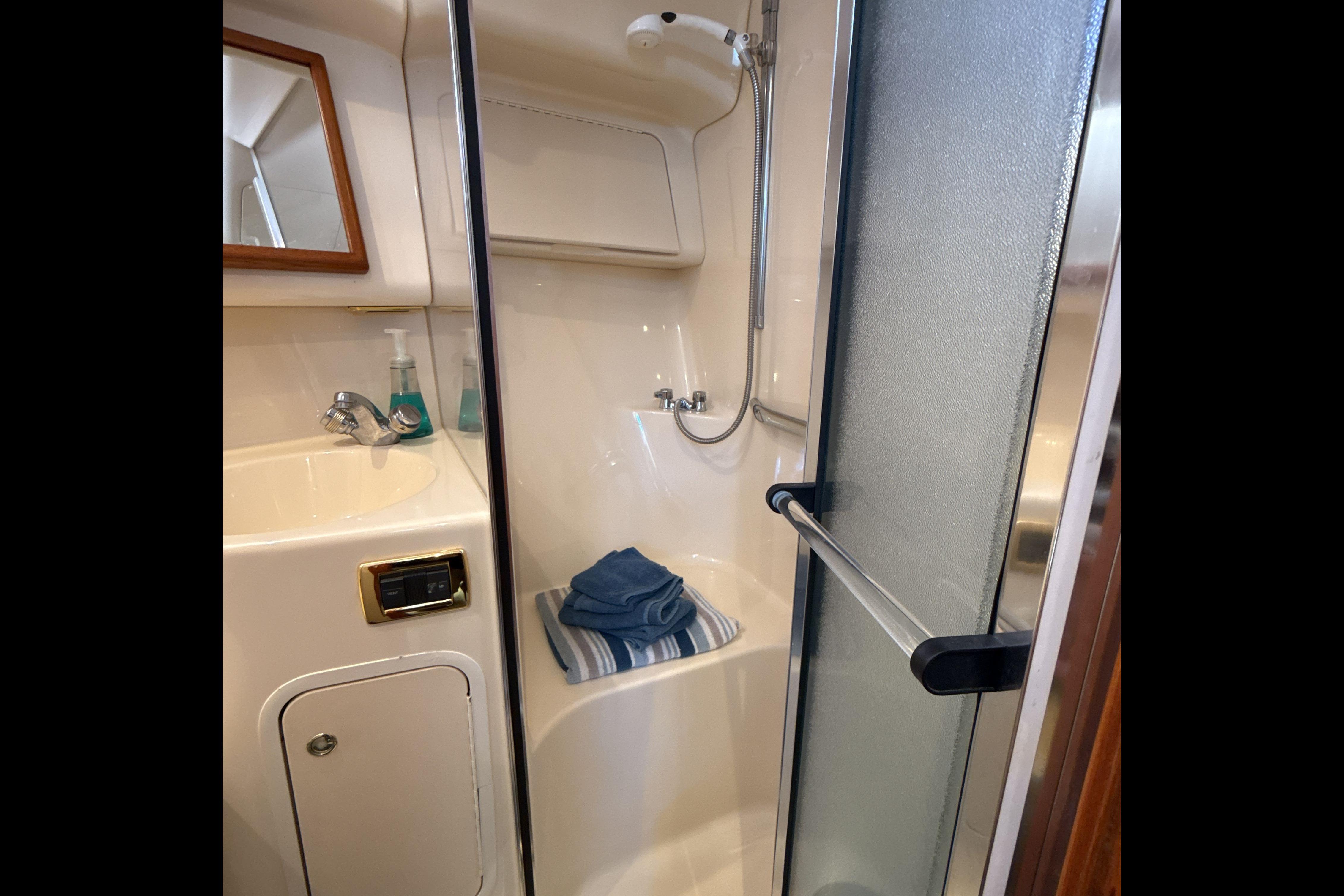 Bathroom interior of 2001 Sea Ray 400 Sedan Bridge yacht with shower and sink.