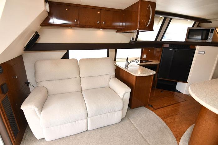 Interior of 2008 Carver 43 Super Sport yacht with plush seating and modern kitchenette.
