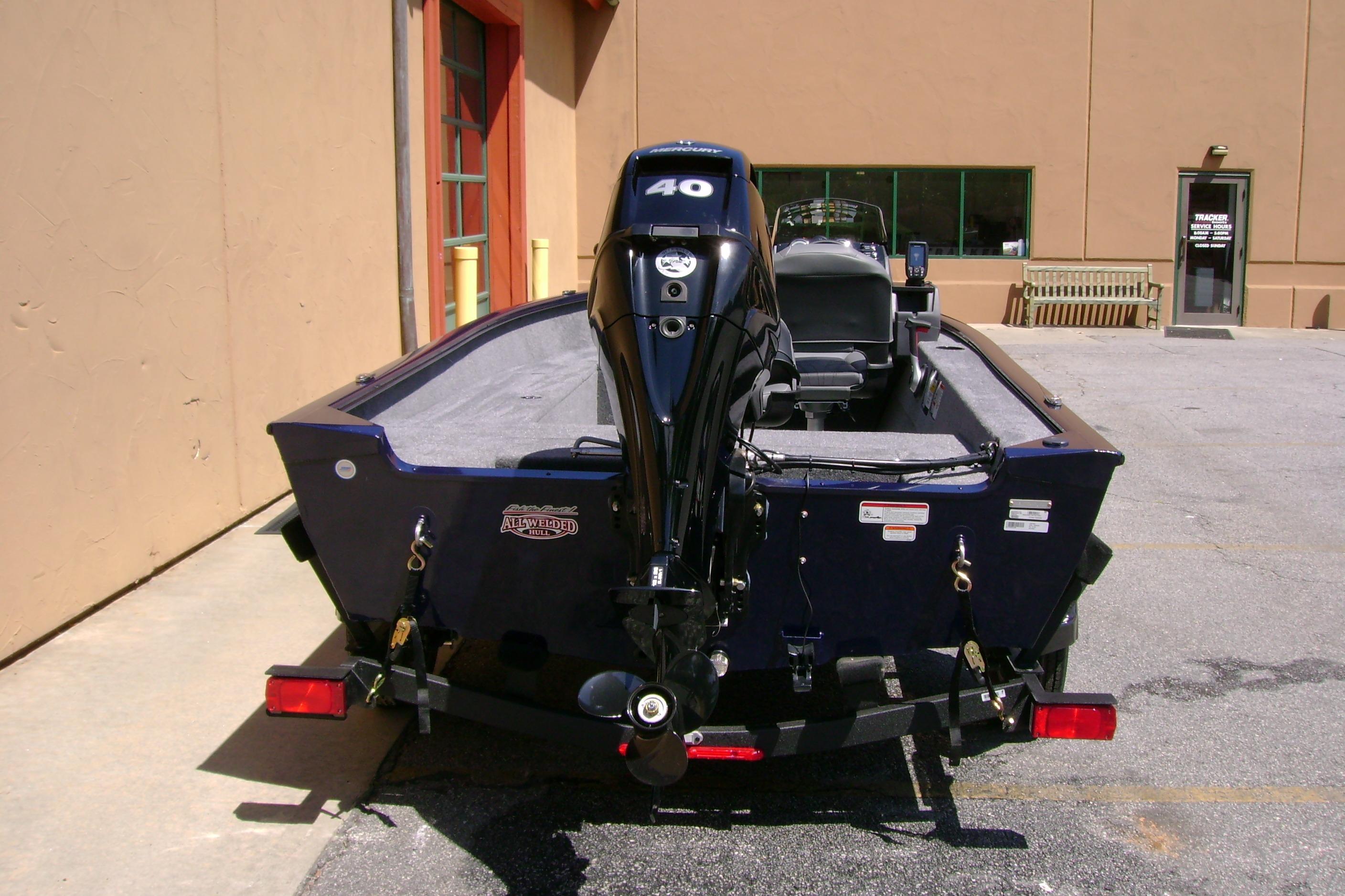 2026 Tracker Super Guide V-16 SC boat with 40 HP motor, parked outside a building.