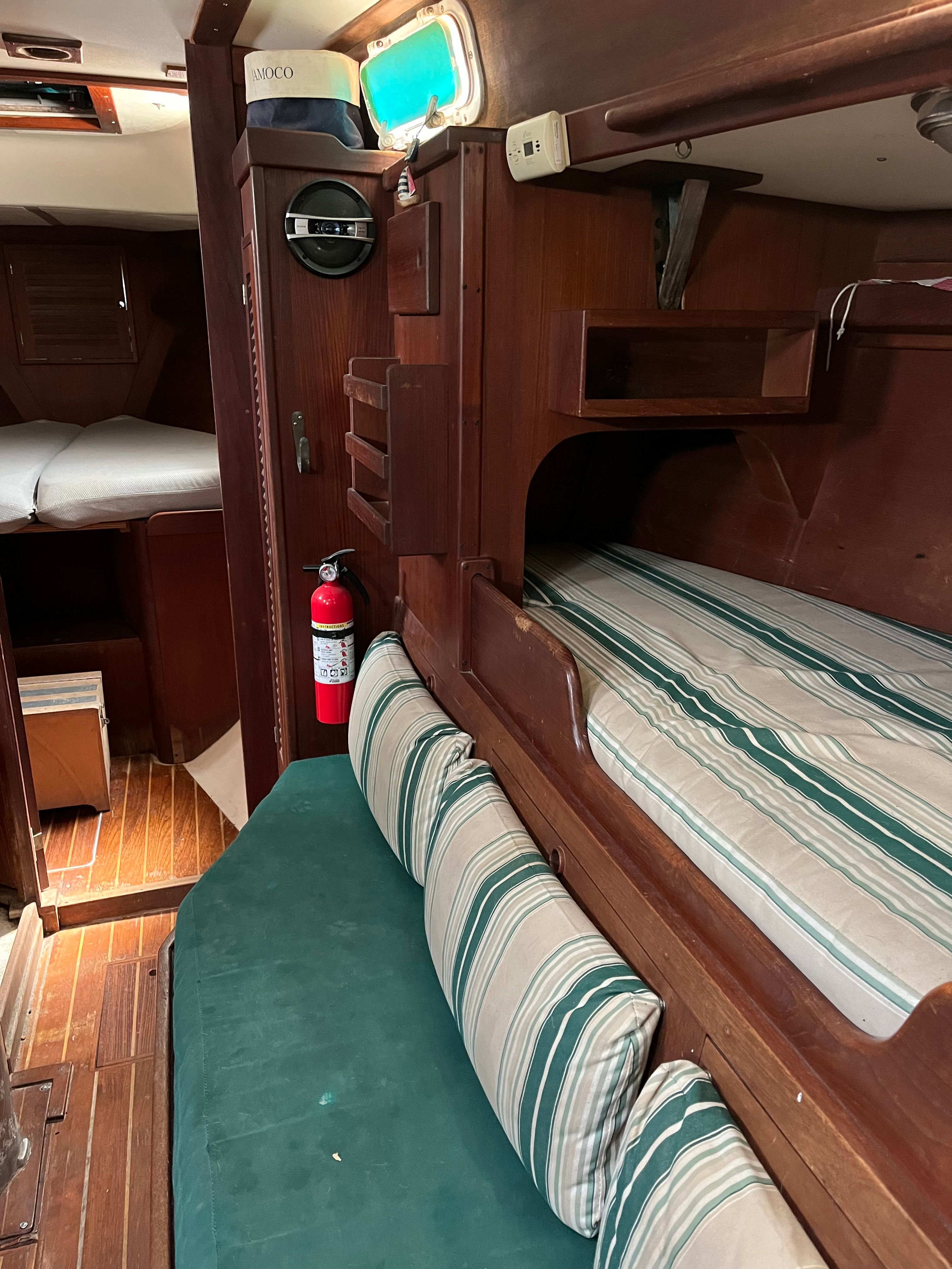 Interior of a 1981 Tartan Sloop with wood finish and striped cushions.