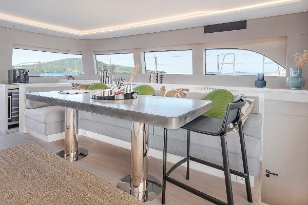 Luxurious interior of 2025 Lagoon SIXTY 5 yacht with modern dining area.