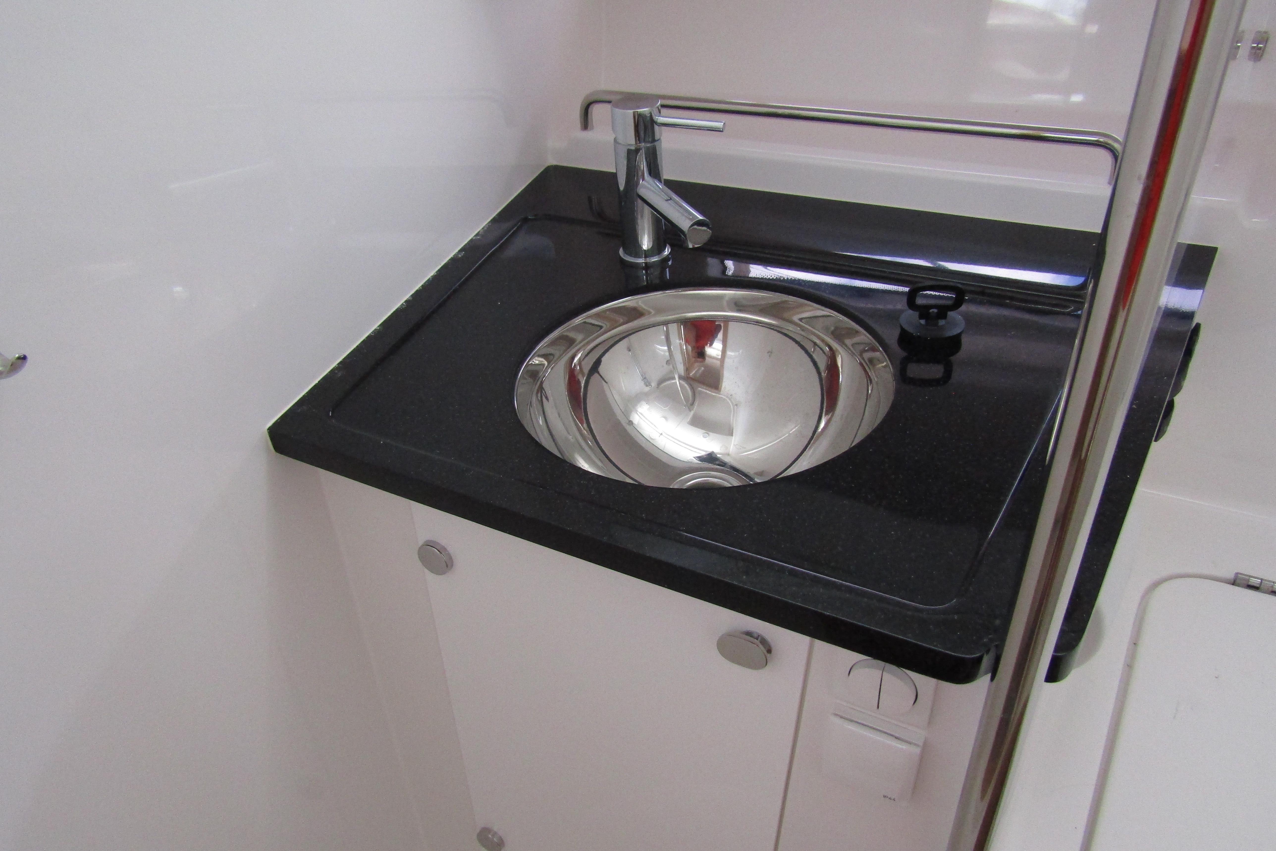 Modern sink area in 2025 Nimbus Tender 11 boat, featuring sleek design and chrome fixtures.
