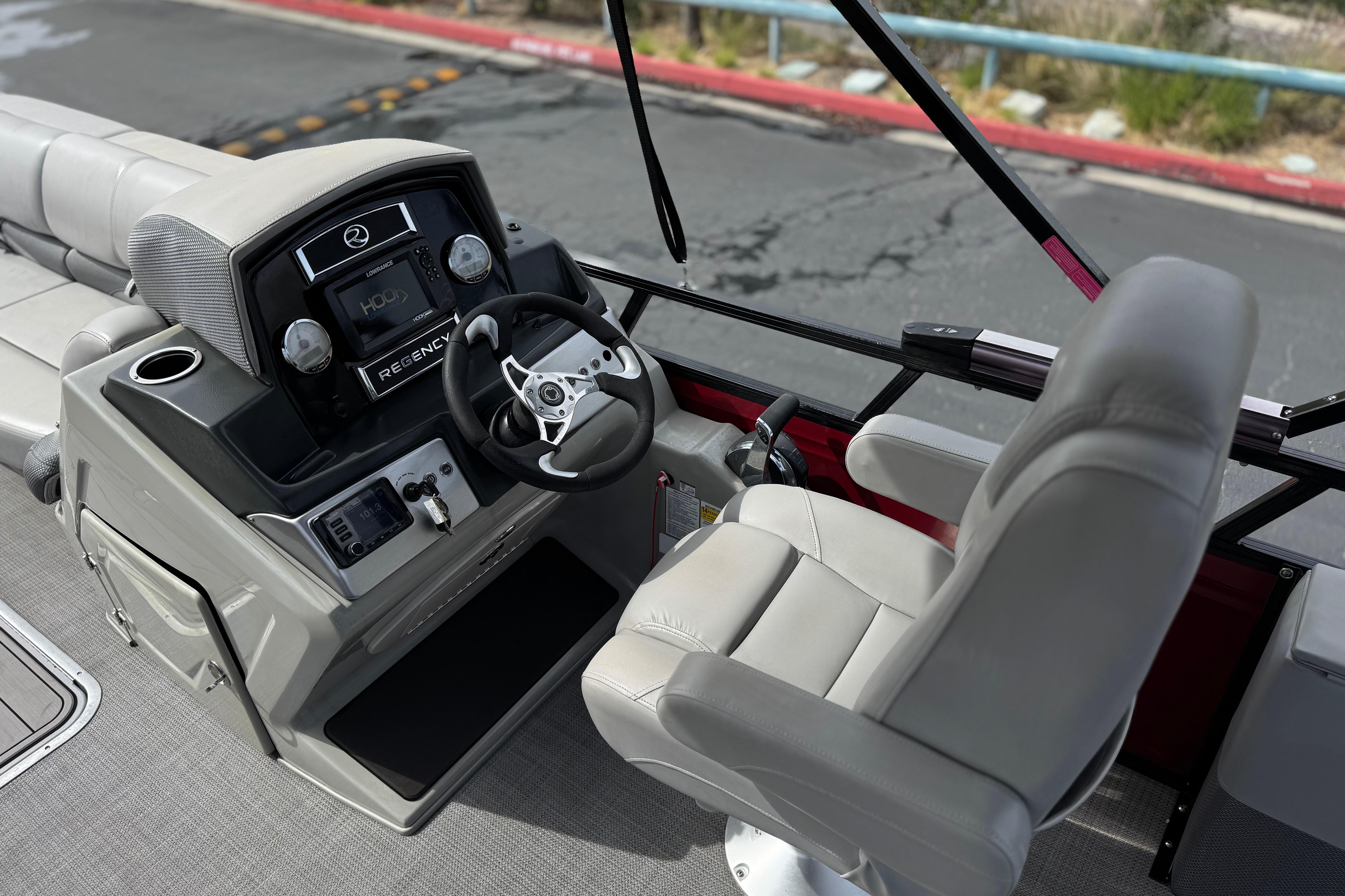 2022 Regency 250 DL3 boat helm with steering wheel and control panel.
