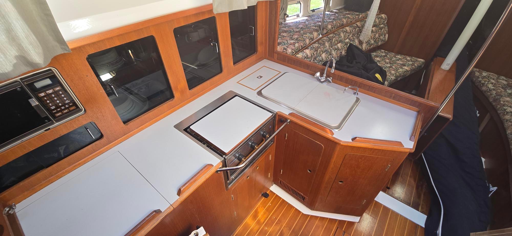 1988 Hunter Legend 37 yacht interior with kitchen, wooden cabinetry, and modern appliances.
