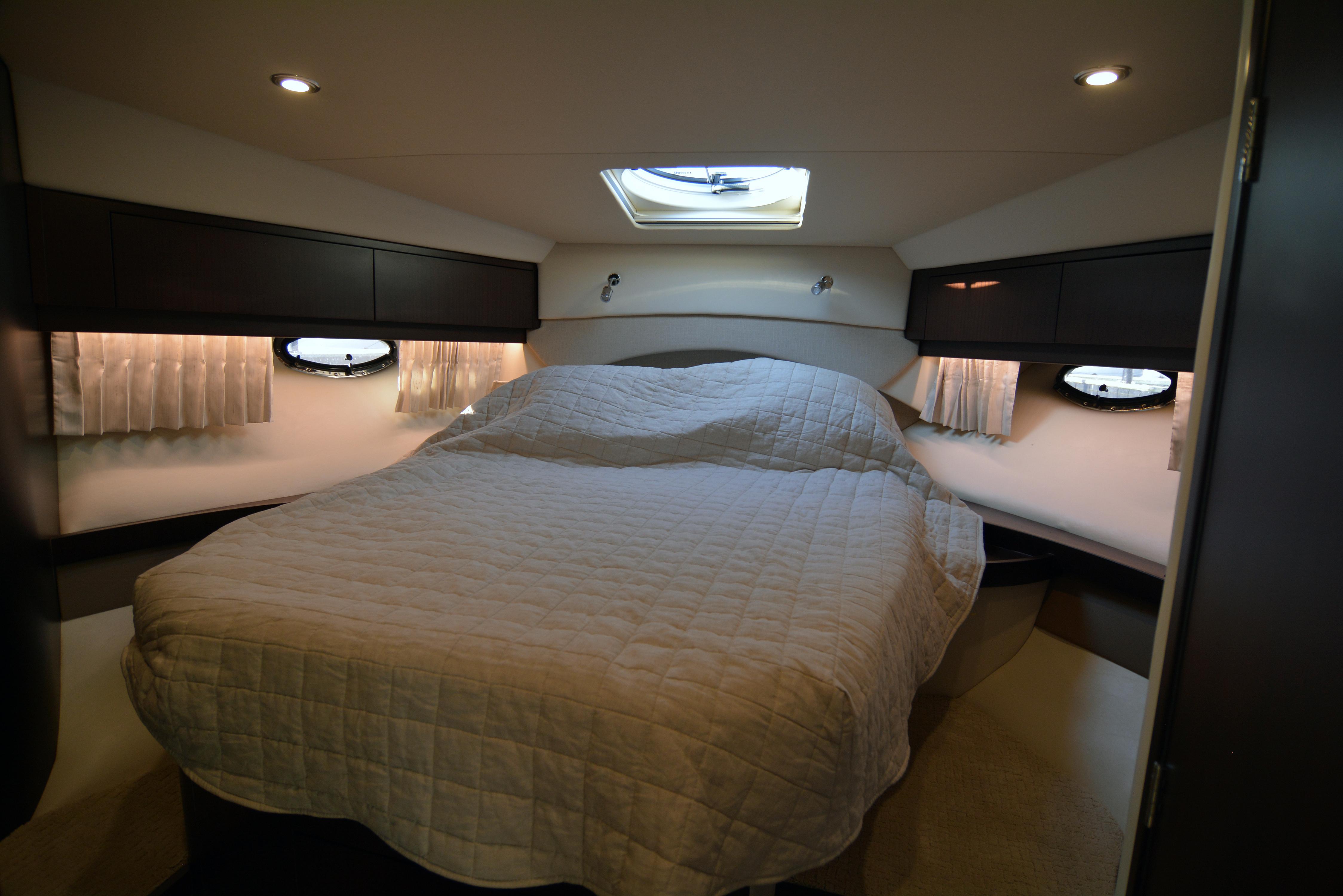 Luxurious cabin interior of 2018 Regal 46 Sport Coupe with cozy bed and ambient lighting.