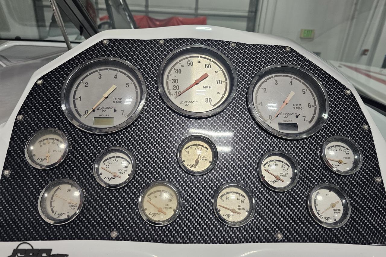 Dashboard of a 2008 Baja 335 Performance boat with multiple gauges and carbon fiber panel.