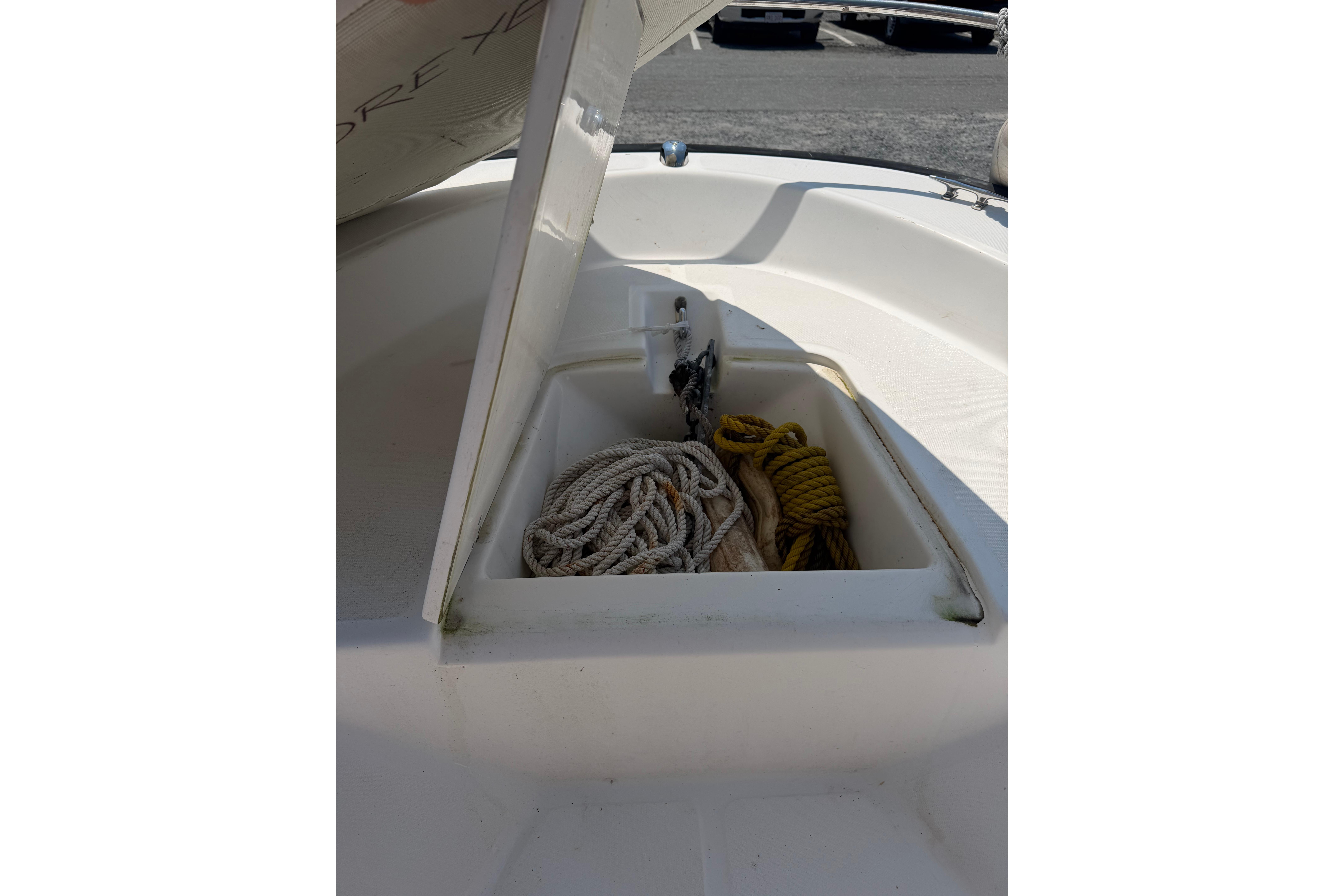 Open storage compartment on 2003 Boston Whaler 130 Super Sport with ropes inside.