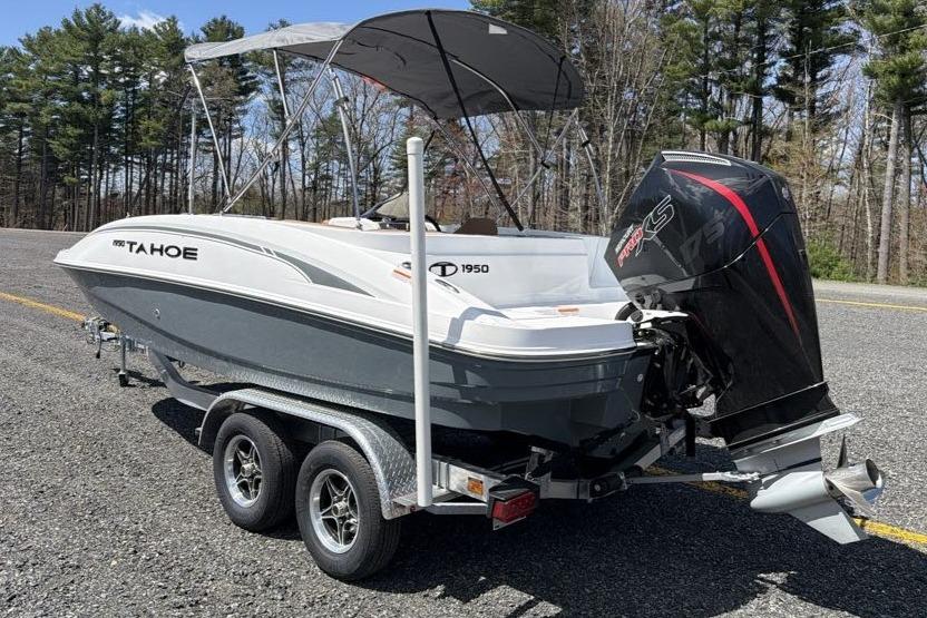2026 Tahoe 1950 boat on trailer with outboard motor, parked on a road.