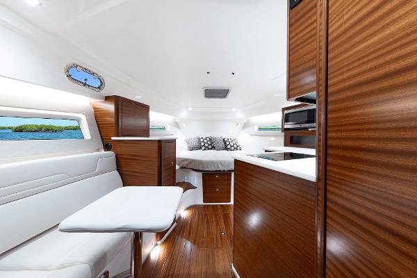 Luxurious interior of 2025 Pursuit OS 405 yacht with modern wood finishes and cozy seating.