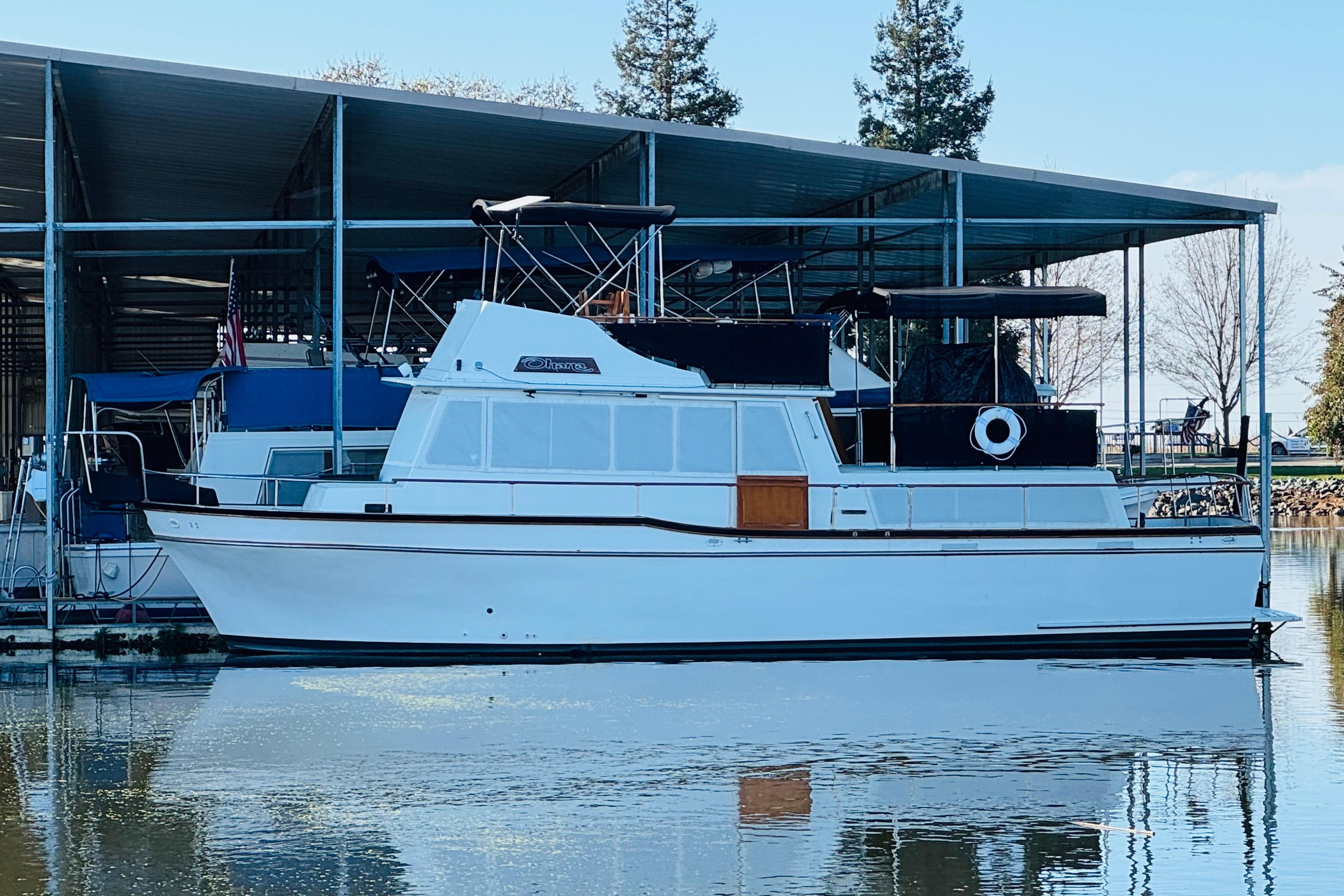 1978 Californian 42 LRC yacht docked in marina, reflecting on calm water.